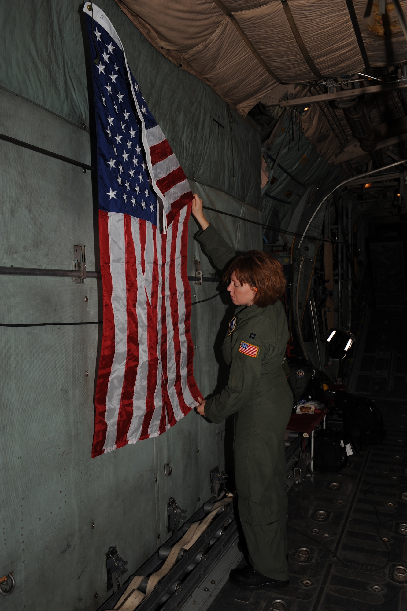 DYESS AIR FORCE, Texas- Captain Jamie Ratcliff, Wright-Patterson Air Force Base, Ohio, hangs the 
American flag inside a  C-130 out of Dyess AFB, Texas, while in flight from Little Rock Air Force Base, Arkansas  to Corpus Christi, Texas , Sept. 11. Captain Ratcliff along with 4 other Airmen were sent to Little Rock Air Force Base, Arkansas, to ride with the C-130 to Corpus Christi to assist in the evacuation of patients in the path of Hurricane Ike. The Air Force and other military forces not only respond in support of war efforts abroad but also to threats on the home front including natural disasters. (U.S. Air Force photo/ Senior Airman Courtney Richardson)
