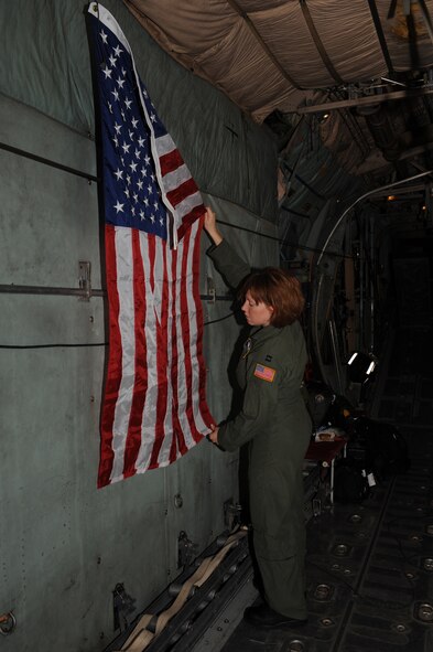 DYESS AIR FORCE, Texas- Captain Jamie Ratcliff, Wright-Patterson Air Force Base, Ohio, hangs the American flag inside a  C-130 out of Dyess AFB, Texas, while in flight from Little Rock Air Force Base, Arkansas  to Corpus Christi, Texas , Sept. 11. Captain Ratcliff along with 4 other Airmen were sent to Little Rock Air Force Base, Arkansas, to ride with the C-130 to Corpus Christi to assist in the evacuation of patients in the path of Hurricane Ike. The Air Force and other military forces not only respond in support of war efforts abroad but also to threats on the home front including natural disasters. (U.S. Air Force photo/ Senior Airman Courtney Richardson)