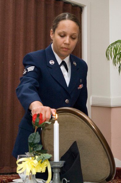 HANSCOM AFB, Mass. -- "The candle is reminiscent of the light of hope which lives in our hearts to illuminate their way home, away from their captors, to the open arms of a grateful nation."
Senior Airman Amanda Carter, 66th Medical Operations Squadron dental technician, leads a ceremony honoring prisoners of war and servicemembers missing in action Sept. 4. Such ceremonies are held before many official base events to honor and remember fallen comrades. National POW/MIA Day is Sept. 19. The POW(U.S. Air Force photo by Mark Wyatt)
