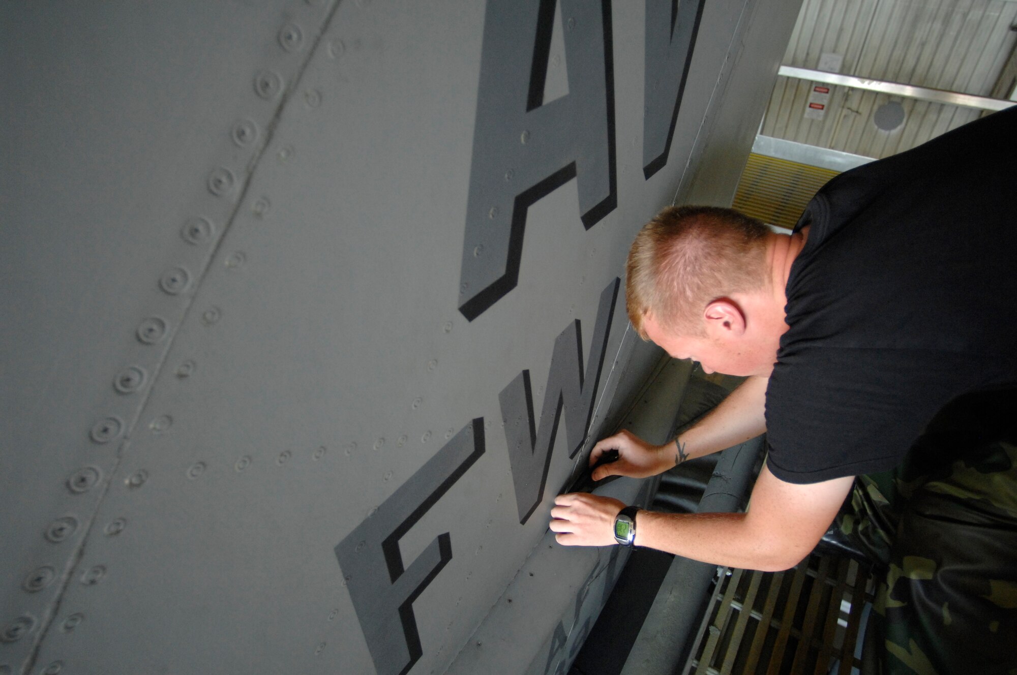 Airman 1st Class Brandon Frazier, 31st Aircraft Maintenance Squadron, places protective tape on parts of an F-16 that cannot become wet before he begins washing it Sept. 9 in the base wash rack. If water leaks in, electrical damage can occur. The Aviano F-16 fleet is routinely washed every six months or as needed to maintain professional looking and corrosion-free aircraft. (U.S. Air Force photo/Airman 1st Class Ashley Wood)
