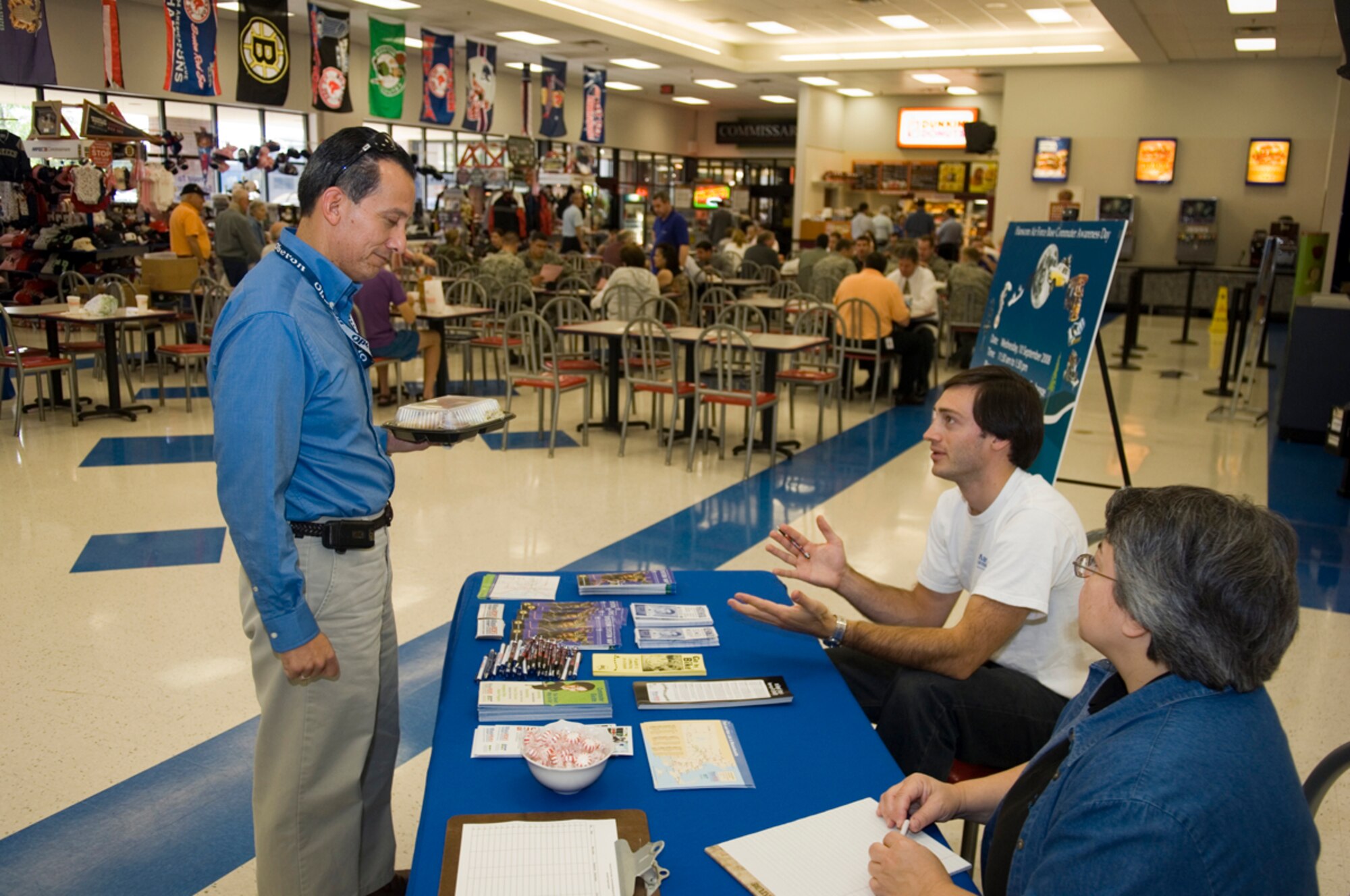 HANSCOM AFB, Mass. -- Dan Sanchez, 652nd Electronic Systems Squadron contractor, learns about carpooling options from Elliot Schmidt, outreach coordinator for the Massachusetts Department of Transportation's MASSRIDES office, and Linda Arpino, 66th Mission Support Group Environmental office, at a commuter awareness booth in the Hanscom Base Exchange complex Sept. 10. Hanscom employees interested in public transportation or carpooling have several programs available to them. The Ride Matching program, which is run by the Environmental office, pairs employees with similar work schedules to facilitate carpooling. Vanpools are also available for larger commuter groups. Additionally, employees using public transportation may qualify for the Transportation Incentive Program -- a Department of Defense program that provides financial incentives to employees to encourage commuting by mass transportation. (U.S. Air Force photo by Rick Berry)