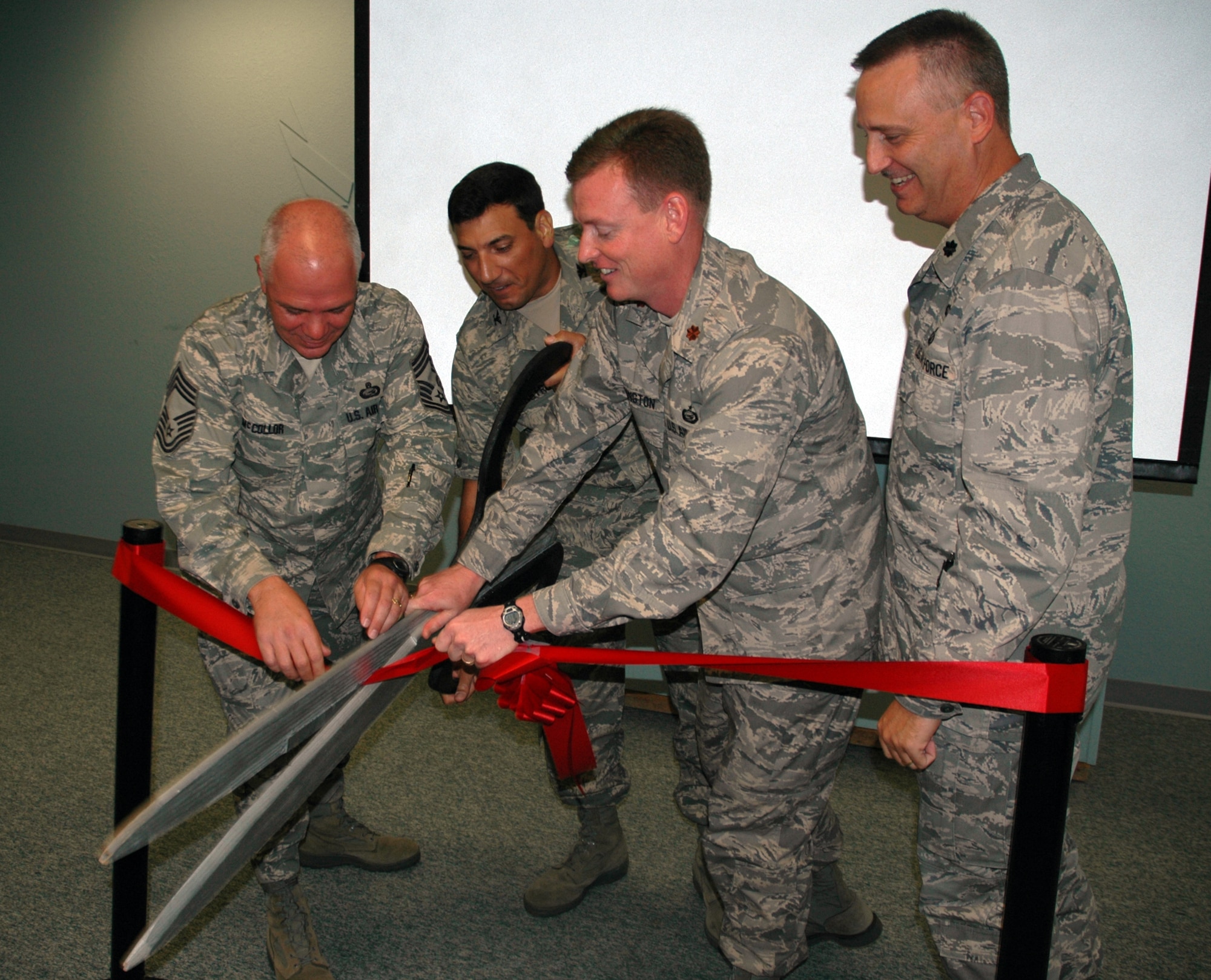 EGLIN AIR FORCE BASE, Fla. -- (From Left) Chief Master Sgt. Christopher McCollor, 96 Mission Support Group command chief, Col. Rick LoCastro, 96th Air Base Wing vice commander, Maj. Sean harrington, 96th Mission Support Squadron commander, Lt. Col. Christopher Wheeler, 96 Mission Suport Group commander, participate in the ceremonial ribbon cutting to signify the completion of the final stage of consolidating personnel to the Military Personnel Flight. (US Air Force photo/ Airman 1st Class Anthony Jennings)