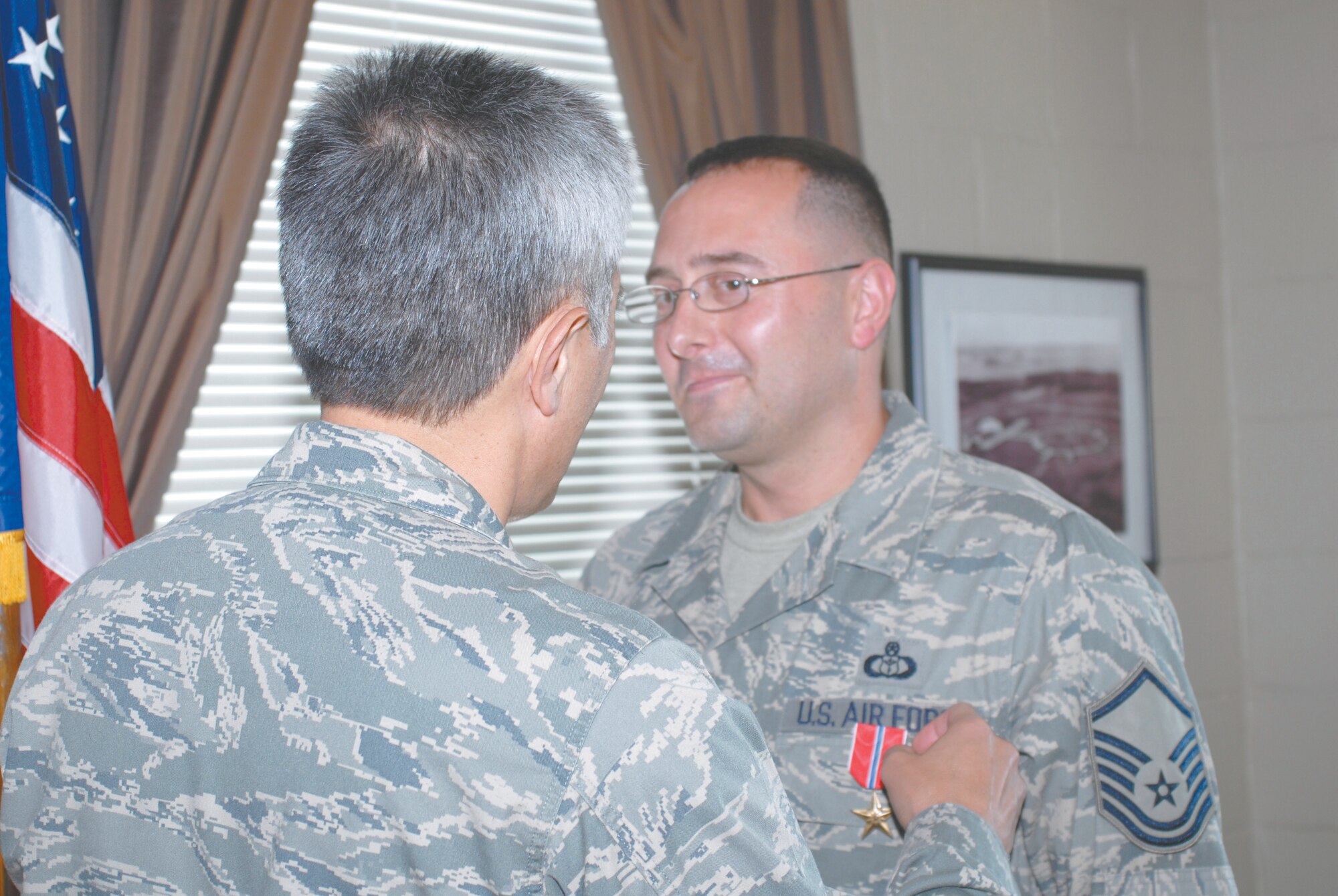 Master Sgt. John Robbins, 18th Weather Squadron, receives the Bronze Star Medal from Col. Patrick Pihana, 18th Air Support Operations Group Commander, during a ceremony Sept. 4 at Felker Army Airfield on Fort Eustis, Va. Robbins was nominated for the medal by the Army while assigned to the 18th Expeditionary Weather Squadron at Camp Victory, Iraq, from September 2007 to March 2008, in support of Operation Iraqi Freedom. Robbins designed a comprehensive weather support plan, resulting in the integration of operational weather forecasts in to more than 700 named operations. Robbins said he was thankful to be nominated. “I did a lot of things I’m proud of,” Robbins said. (U.S. Air Force Photo by Zack Shelby)