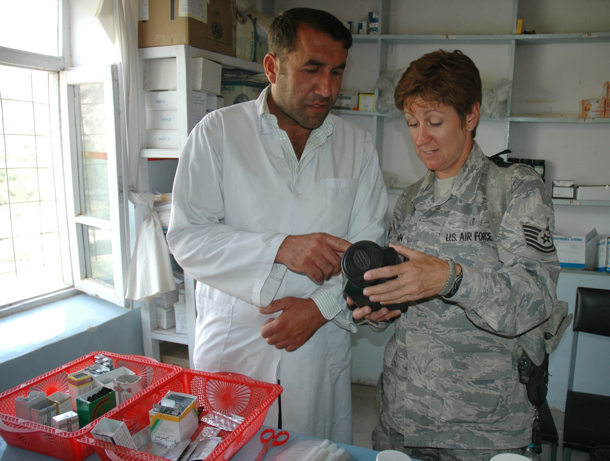 BAGRAM AIR FIELD, Afghanistan -- Tech. Sgt. Dawn Tiemann, Panjshir Provincial Reconstruction Team medical technician, and Dr. Abdul Momin review medications in the Shotul Clinic Parmacy, September 14, 2008. Doctors in Panjshir treated 473 Afghan patients in two districts, Rohka and Shutol, with the Panjshir PRT medical team assisting. (courtesy photo)