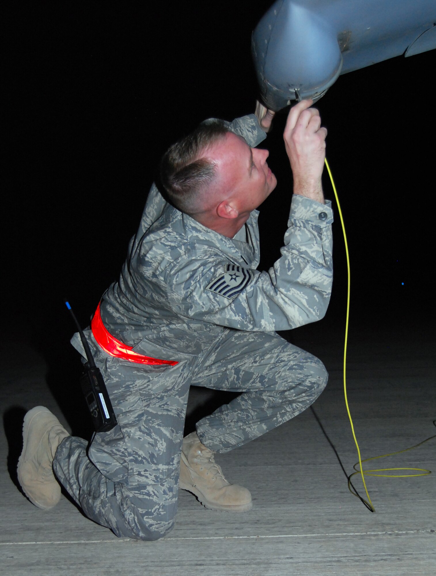 JOINT BASE BALAD, Iraq -- Tech. Sgt. Michael Smith connects a grounding wire to the left wing of an AV-8B Harrier here as part of a refueling operation Sept. 9. The Harrier landed at Joint Base Balad due to inclement weather conditions over al-Asad Air Base in Anbar Province. Smith, a tactical aircraft mainenance craftsman with the 332nd Expeditionary Maintenance Squadron here, is deployed from the Air National Guard's 110th Fighter Wing at Battle Creek, Mich. The Harriers are deployed from Marine Attack Squadron 311 at Marine Corps Air Station Yuma, Ariz. (U.S. Air Force photo/Staff Sgt. Don Branum)