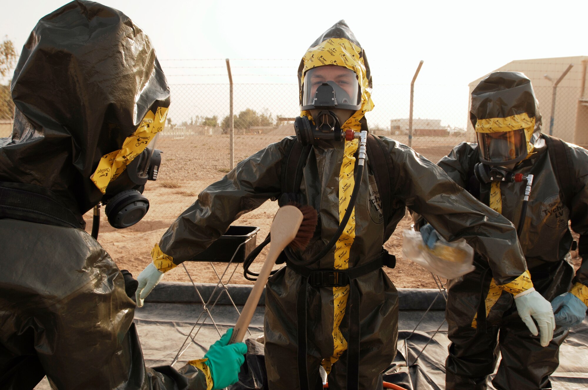 JOINT BASE BALAD, Iraq -- Airman 1st Class Burnie Cobb (left) and Staff Sgt. Bryan Dudley (right) simulate decontaminating Senior Airman Heidi Williams here Sept. 11. These 332nd Civil Engineer Squadron Emergency Management Flight Airmen conduct simulation exercises to practice their proficiency at responding to chemical, biological, radiological nuclear and environmental incidents. Williams is deployed from Beale Air Force Base, Calif., and her hometown is Plymouth, Ind. Cobb is deployed from Tyndall Air Force Base, Fla., and his hometown is Bridgewater, Mass. Dudley is deployed from Fairchild Air Force Base, Wa., and his hometown is Newton, N.H. (U.S. Air Force photo/Airman 1st Class Jason Epley)