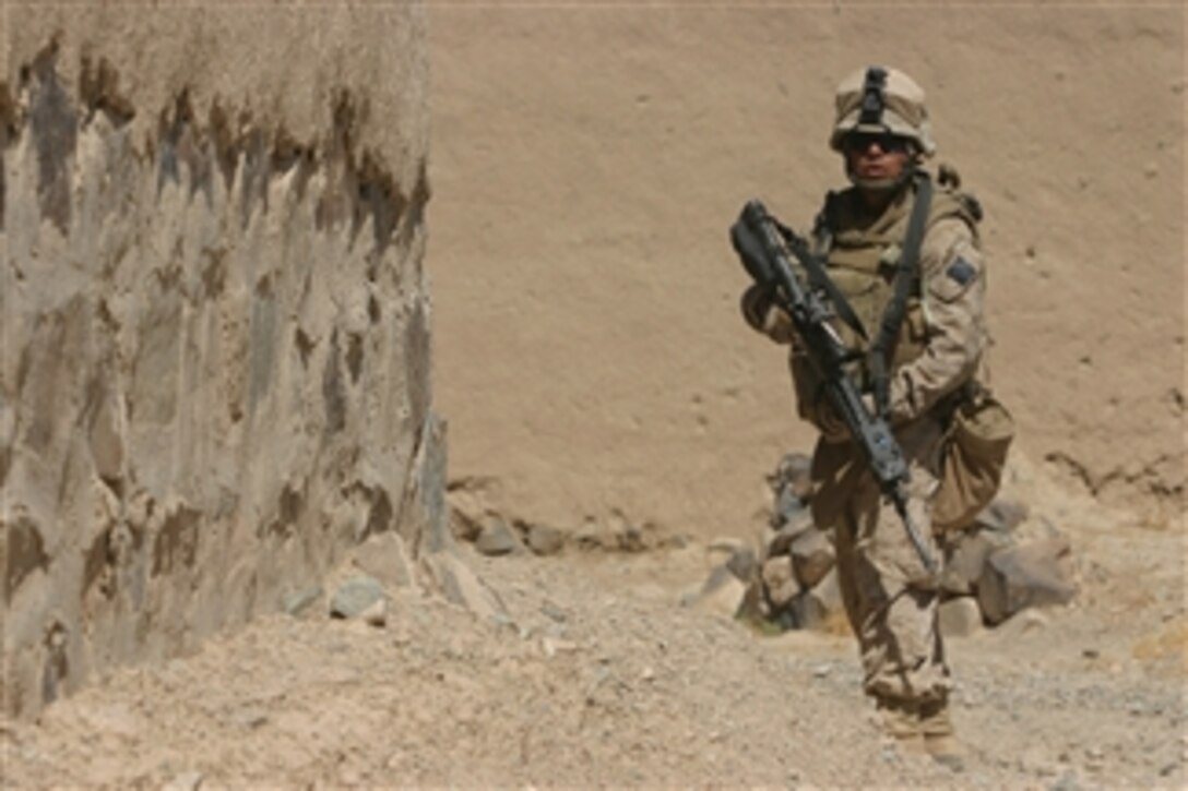 U.S. Marine Corps Gunnery Sgt. Marlin Villacres, platoon sergeant of 3rd Combat Engineer Battalion, 2nd Battalion, 7th Marine Regiment, checks his rear security during a patrol in Now Zad, Afghanistan, on Sept. 12, 2008.  The Marine unit, which is a reinforced light infantry battalion, is clearing the city of improvised explosive devices.  