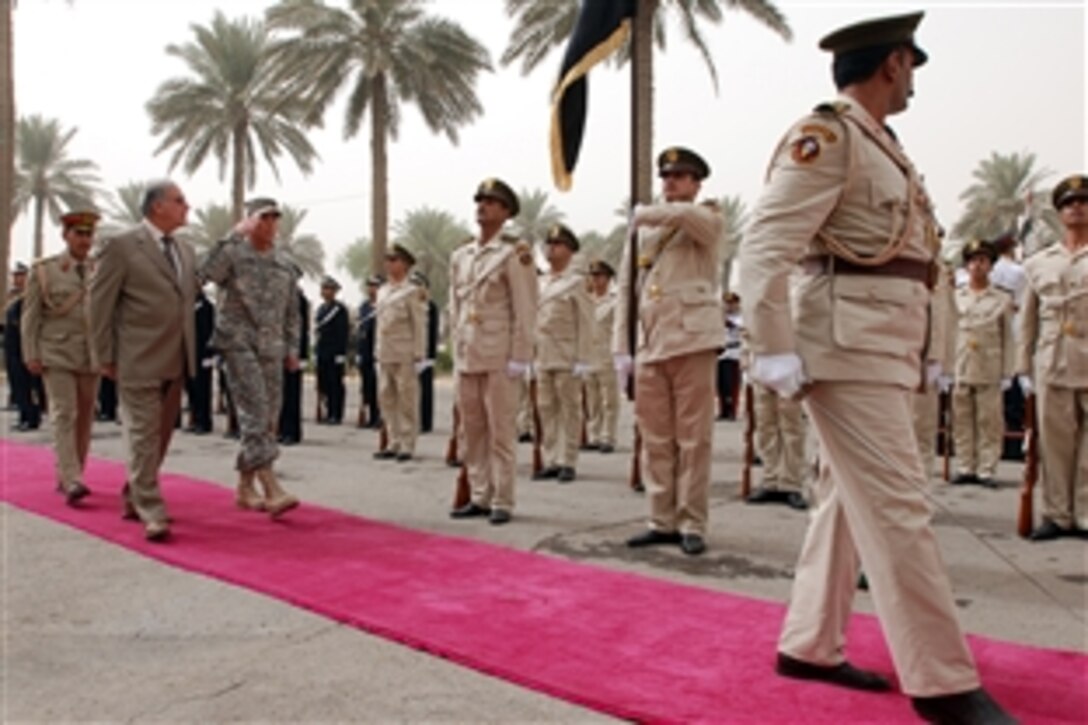 U.S. Army Gen. David H. Petraeus and Iraqi Defense Minister Abdul Qadir salute while passing the Iraqi flag during a Sept. 15, 2008, farewell ceremony in Baghdad for the outgoing American general. Petraeus will turn over command of Multi-National Forces - Iraq to Army Gen. Raymond T. Odierno Sept. 16. Petraeus, who has served in three command positions in Iraq since 2003, will assume command of U.S. Central Command. 