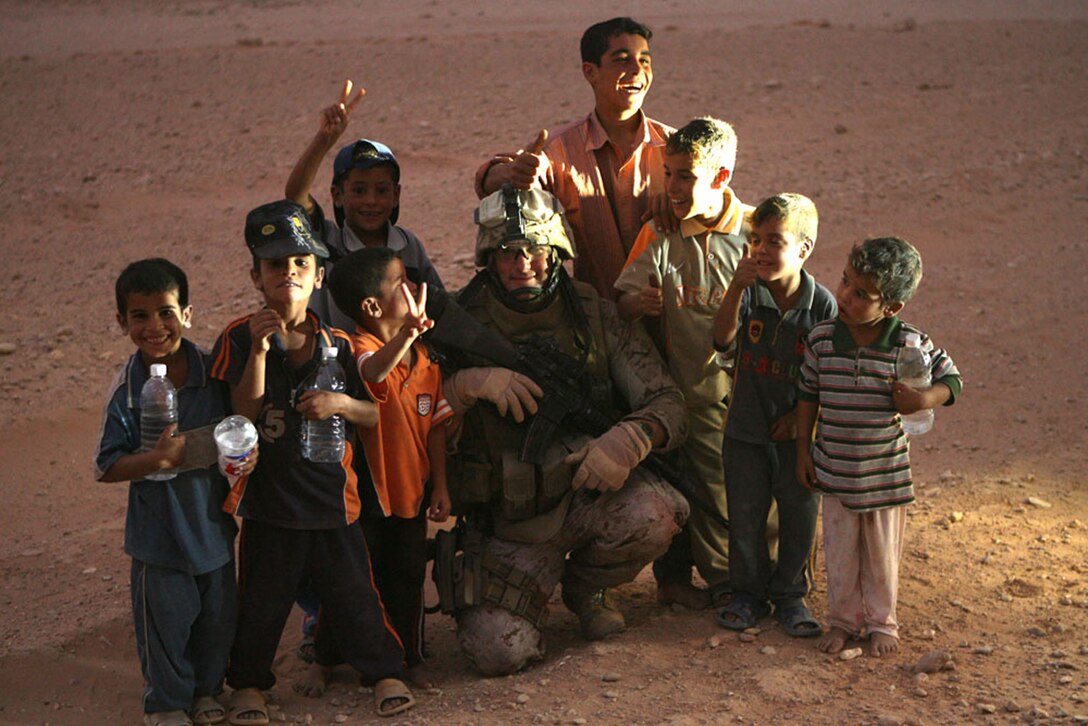 Cpl. Joseph J. Schiller, the squad leader with 3rd Squad, 3rd Platoon, Company F, 2nd Battalion, 25th Marine Regiment, interacts with local children while on a security patrol in al-Anbar province, Iraq, Sept. 16. The Marines and sailors with Company F are attached to Security Bn., 3rd Marine Aircraft Wing (Forward) and will provide external security for Al Asad Air Base during their seven-month deployment.