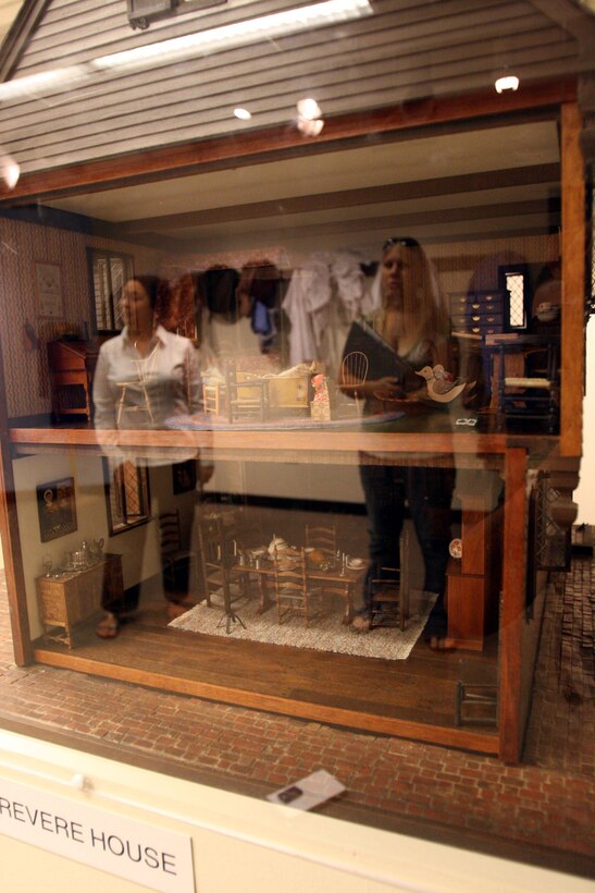 Lesa Griffith (left), museum communications director, and Morgan Magill, Honolulu resident, are reflected in the glass of a small scale reproduction of the Paul Revere house, while touring a room filled with colonial relics at the Honolulu Academy of Art Sept. 16.