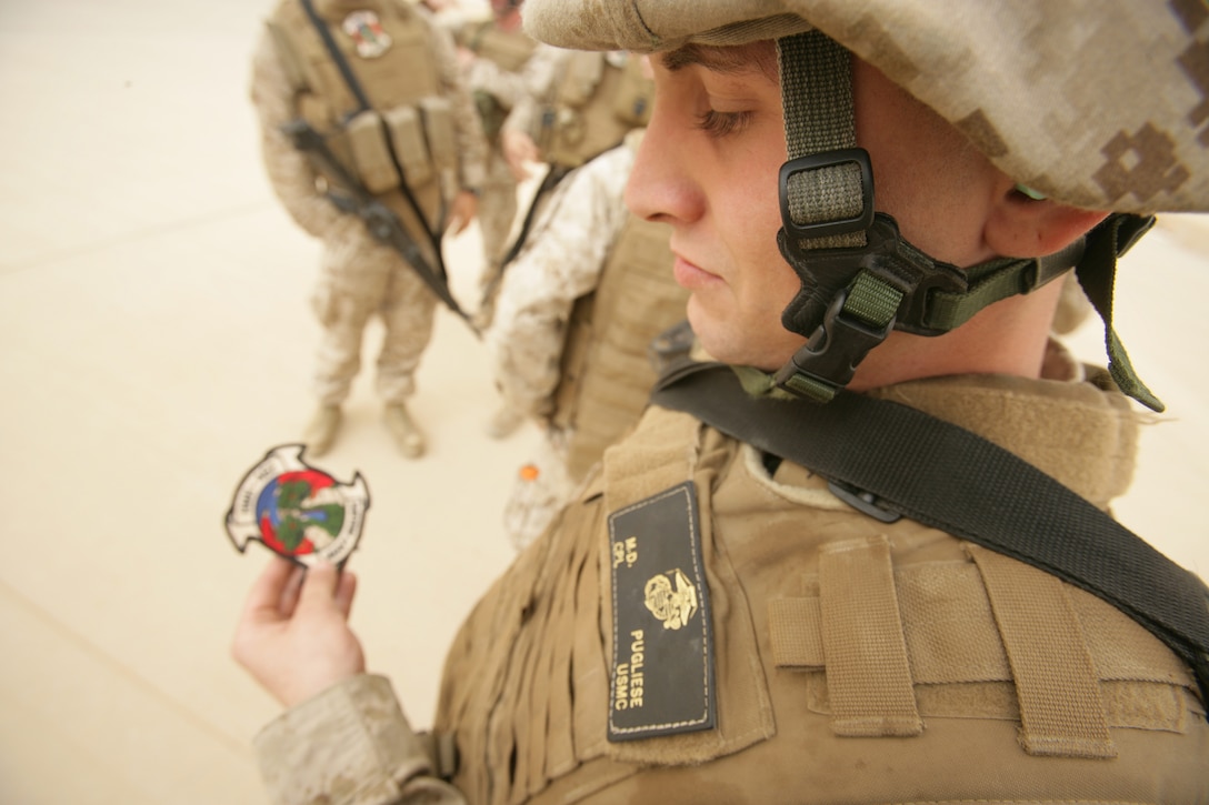 Corporal Michael Pugliese with the Black Knights of Marine Medium Helicopter Squadron 264 (Rein), examines a patch given to him by the commanding officer of the Heavy Haulers of Marine Heavy Helicopter Squadron-462 at Al Asad Air Base, Iraq. Four CH-53Es and about 60 Marines from HMM-264 (Rein), the aviation combat element of the 26th Marine Expeditionary Unit, detached from the MEU to support operations at Al Asad.
