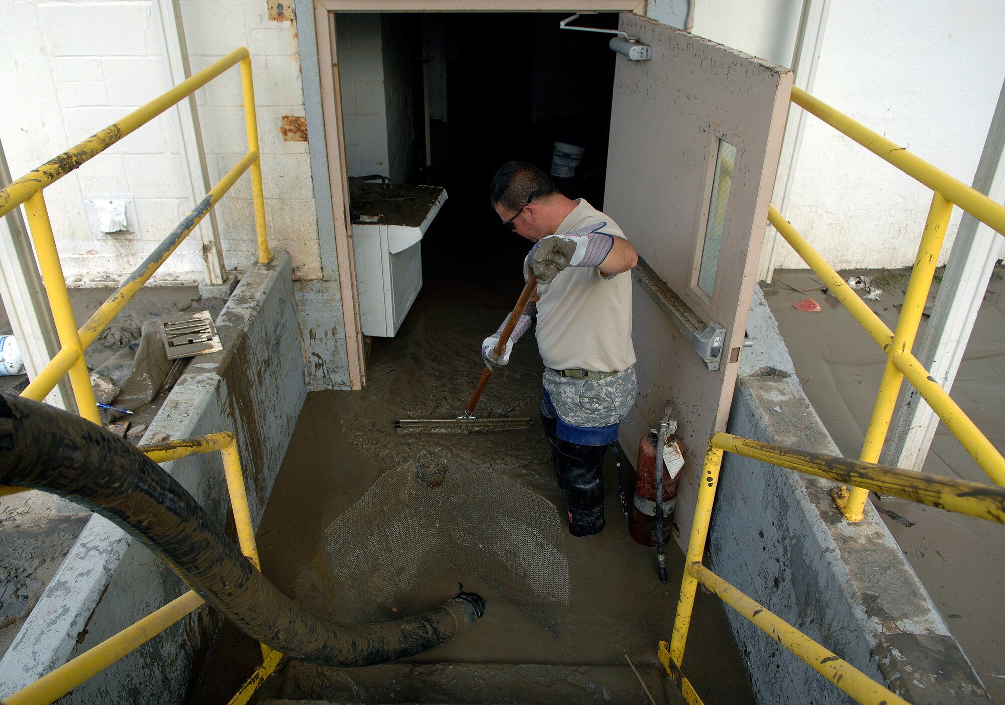 Army Sgt. Damian Edwards sweeps muddy water from the basement level of the Cameron, La., court house Sept. 15. Nearly 2,000 gallons of water were removed due to flooding caused by Hurricane Ike. Sergeant Edwards is a engineer with the 921st Engineering Company of the Louisiana Army National Guard. (U.S. Air Force photo/Staff Sgt. Bennie J. Davis III)