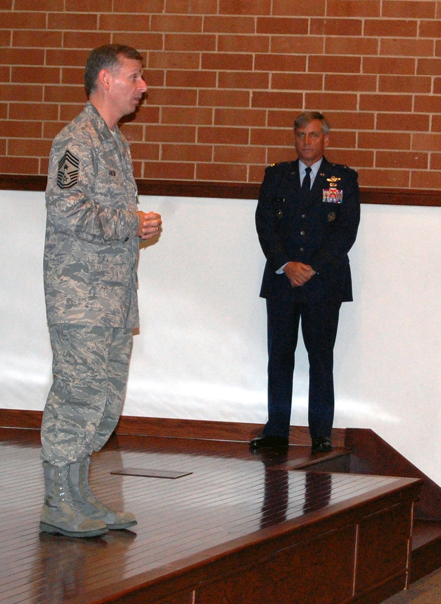 Chief Master Sgt. Jeffry Helm, U.S. Air Force Expeditionary Center's command chief master sergeant from November 2006 to September 2008, bids farewell to the USAF EC "Eagles" during a commander's call Aug. 25, 2008.  Maj. Gen. Kip Self, USAF EC commander, looks on.  Chief Helm moves on to become the command chief for the Army and Air Force Exchange Service in Dallas, Texas.  (U.S. Air Force Photo/Tech. Sgt. Scott T. Sturkol)