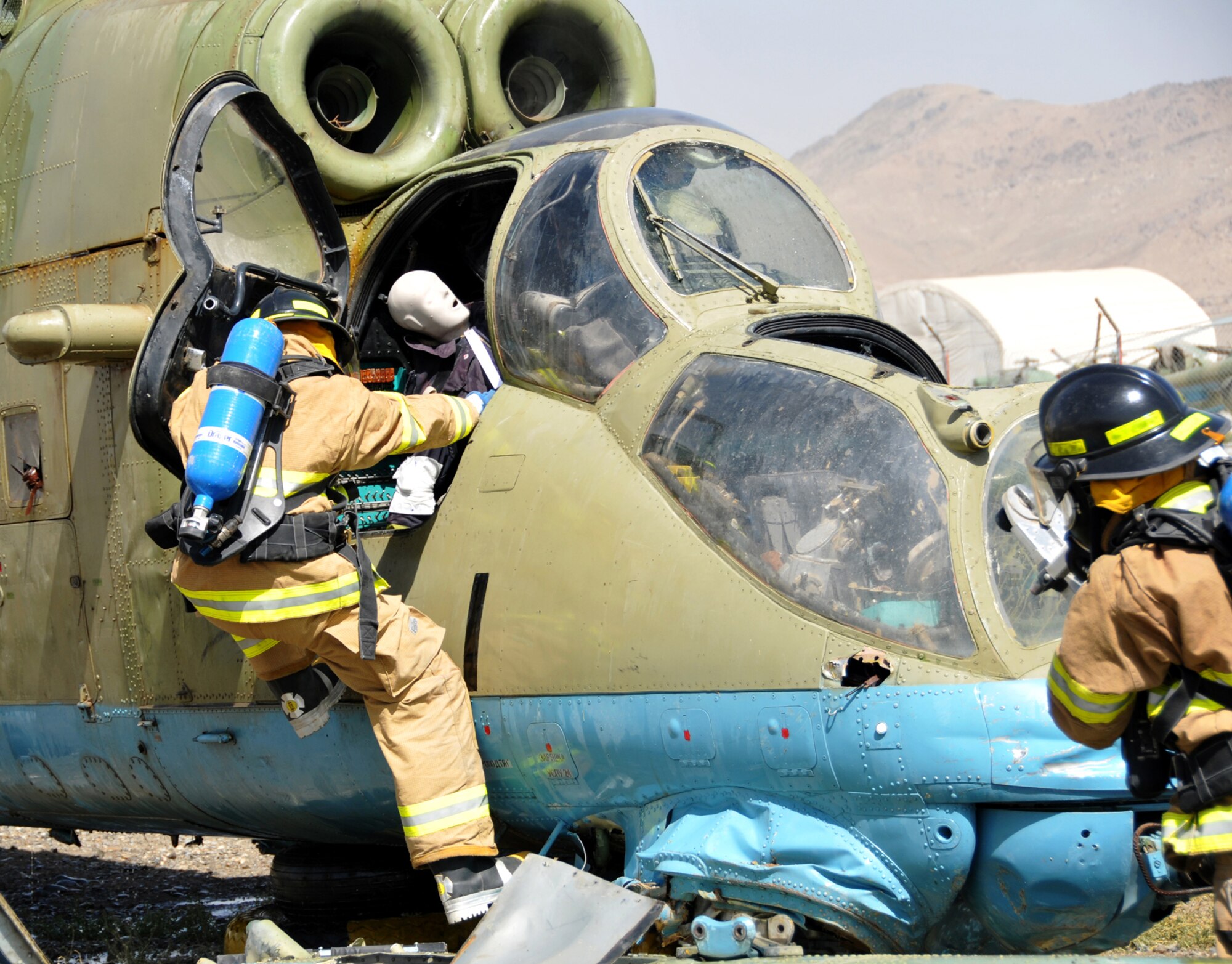 KABUL, Afghanistan -- An Afghan National Army Air Corps fire department member attempts to rescue a simulated downed pilot during an emergency response exercise recently at the Kabul Air Corps Training Center in Afghanistan. Air Corps fire department and quick reaction force members used the live fire exercise to coordinate their response to an aircraft fire.(U.S. Air Force photo/Staff Sgt. Beth Del Vecchio)
