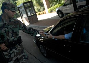 Senior Airman Giles Blumer checks a motorist’s ID card before granting access to Charleston AFB Sept. 16. Security force augmentees from various squadrons help security force Airmen secure the base and protect its assets. Airman Blumer is assigned to the 437th Security Forces Squadron as a security forces augmentee. (U.S. Air Force photo/Tech. Sgt. David Watson)