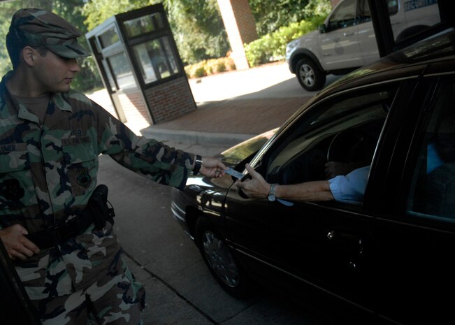 Senior Airman Giles Blumer checks a motorist’s ID card before granting access to Charleston AFB Sept. 16. Security force augmentees from various squadrons help security force Airmen secure the base and protect its assets. Airman Blumer is assigned to the 437th Security Forces Squadron as a security forces augmentee. (U.S. Air Force photo/Tech. Sgt. David Watson)