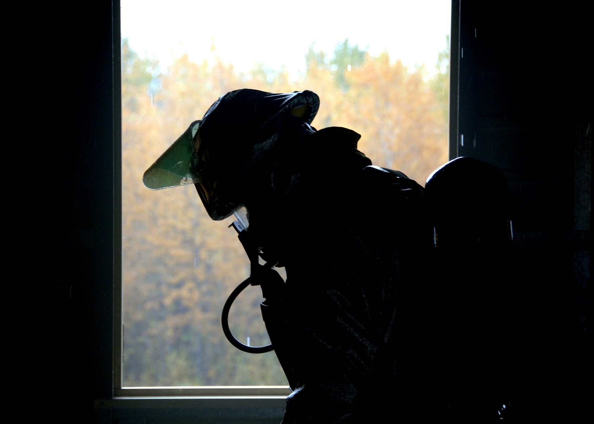 A firefighter from the 354th Civil Engineer Squadron fire protection flight waits for radio contact with his crew chief during a training operation on Sept. 13, 2008, at the live fire training area on Eielson AFB, Alaska. The Firefighters constantly relay information back and forth to get an understanding of the situation and to keep command up to date on the operation. (U.S. Air Force photo by Airman 1st Class Willard E. Grande II)