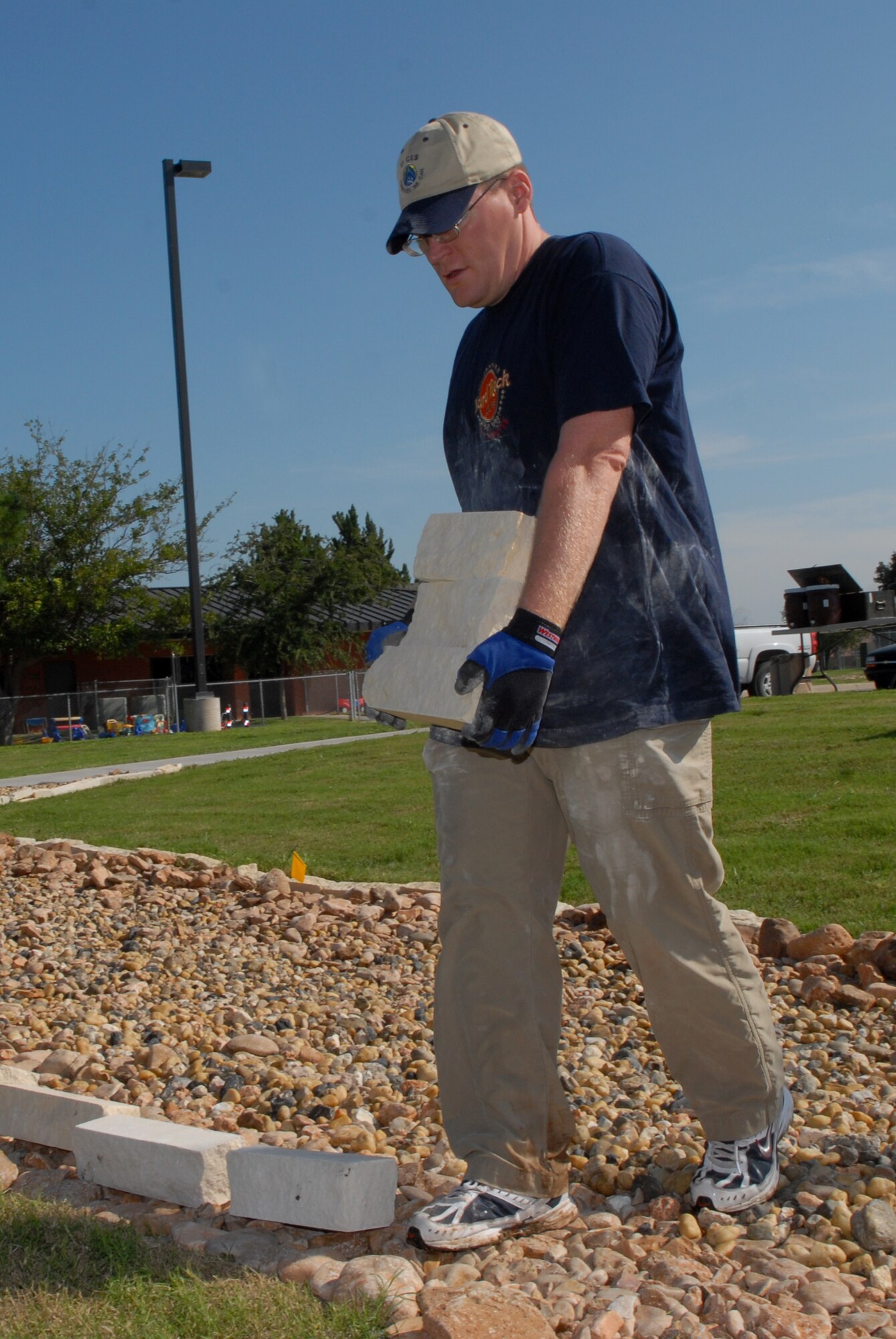 Staff Sgt. Kevin Rodgers, 17th Civil Engineer Squadron readiness flight, carries border rock for the dry riverbed at the Goodfellow School-Age Facility Sept. 13. Taylor Cambre, a Boy Scout from Troop 363, planned and led this undertaking as part of his Eagle Scout service project. Members of the 17 CES volunteered their time to help. (U.S. Air Force photo by Senior Airman Kasabyan Musal)