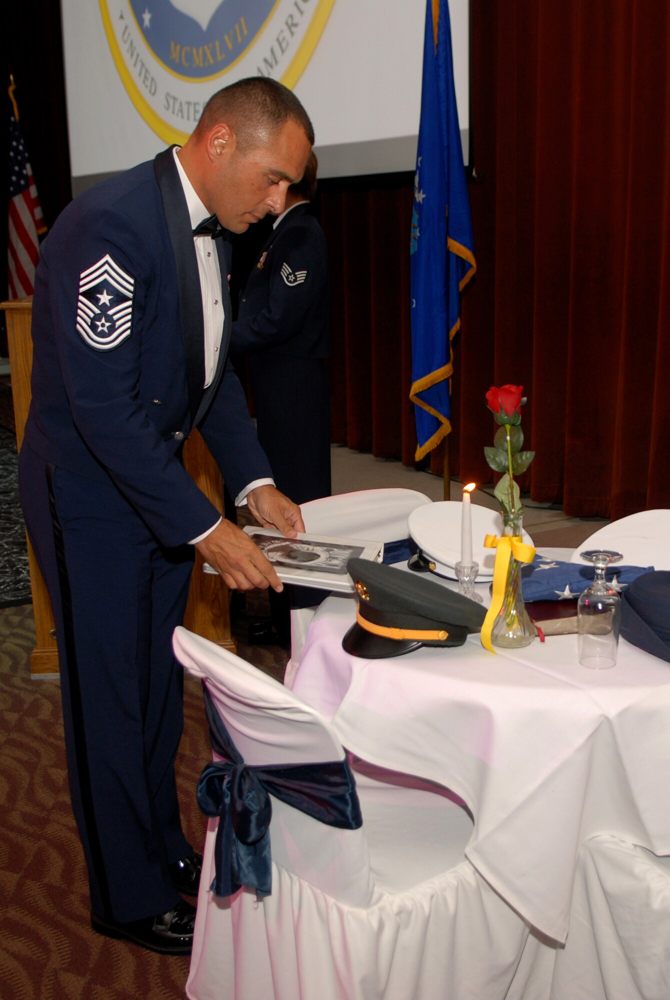 Chief Master Sgt. Frederick Ricker places the book with the names of Prisoners of War and Missing in Action on the POW/MIA table at the 2008 Air Force Ball Sept. 12. (U.S. Air Force photo by Senior Airman Kasabyan Musal)