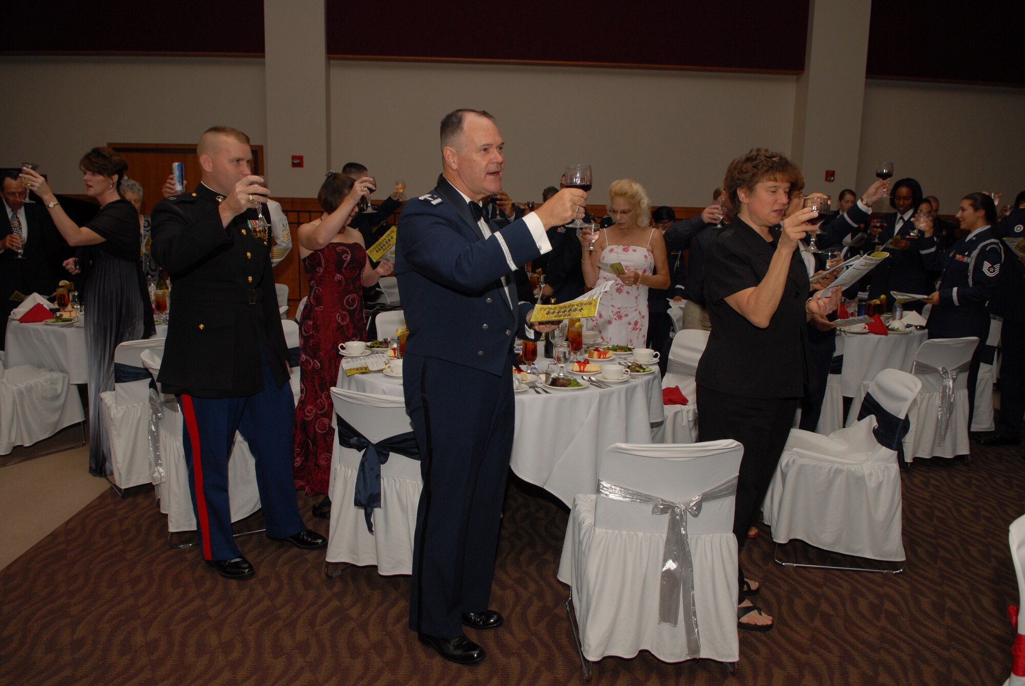Chaplain (Lt. Col.) James Ludwikoski (center) and other attendees at the 2008 Air Force Ball raise a glass in a toast "to our Soldiers, Sailors, Marines and Airmen who are deployed around the world defending freedom and upholding democracy." (U.S. Air Force photo by Senior Airman Kasabyan Musal)