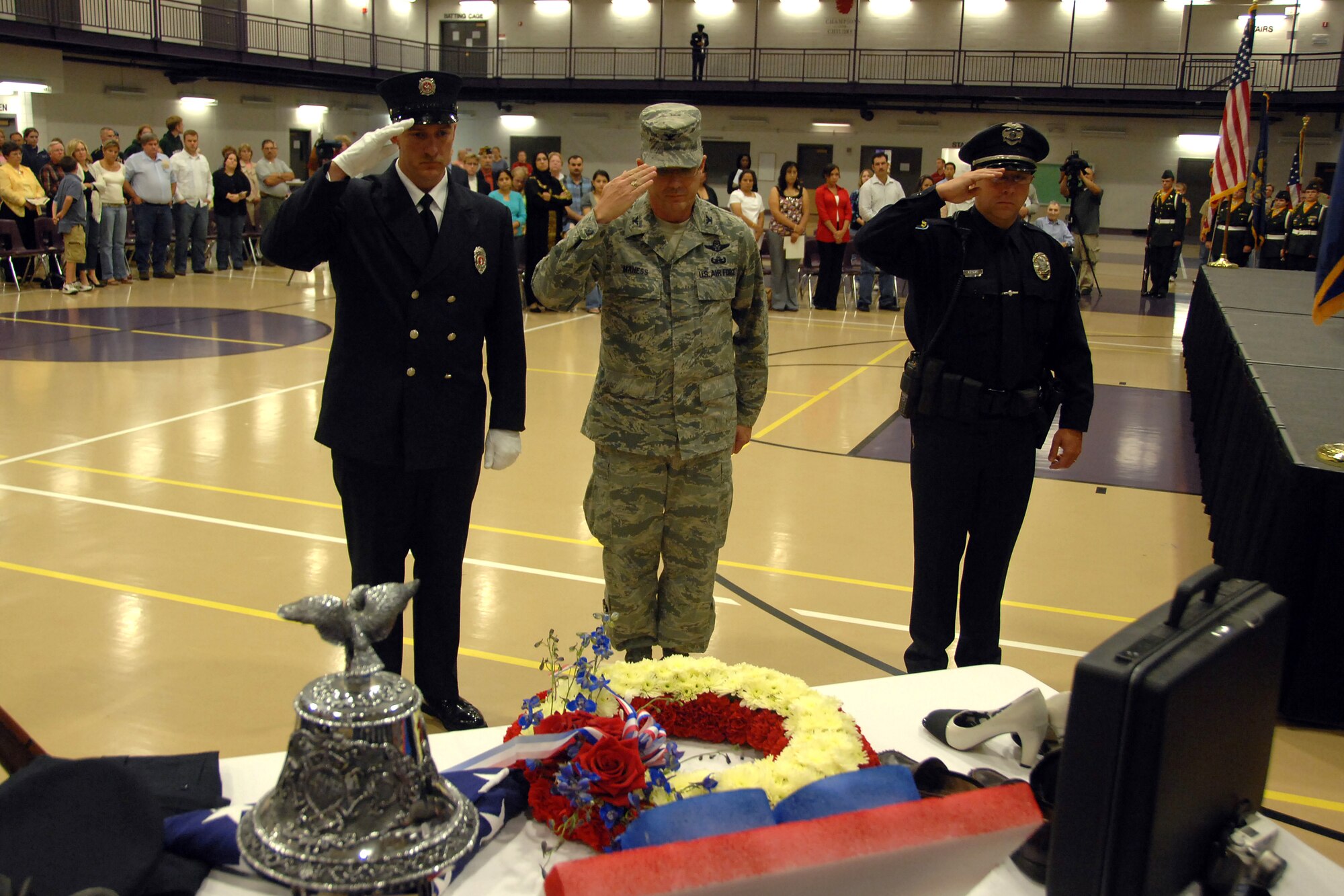 OFFUTT AIR FORCE BASE, Neb -- Colonel Robert Maness, 55th Wing vice commander, and representatives from the Bellevue Volunteer Fire Department and Bellevue Police Department render a salute to a display representing the fallen Sept. 11 during a special ceremony honoring victims of Sept. 11, 2001 held at the Bellevue Lied Center. The ceremony featured the ringing of the “Four Fives,” a tradition that honors fallen firefighters. (U.S. Air Force Photo By Josh Plueger)