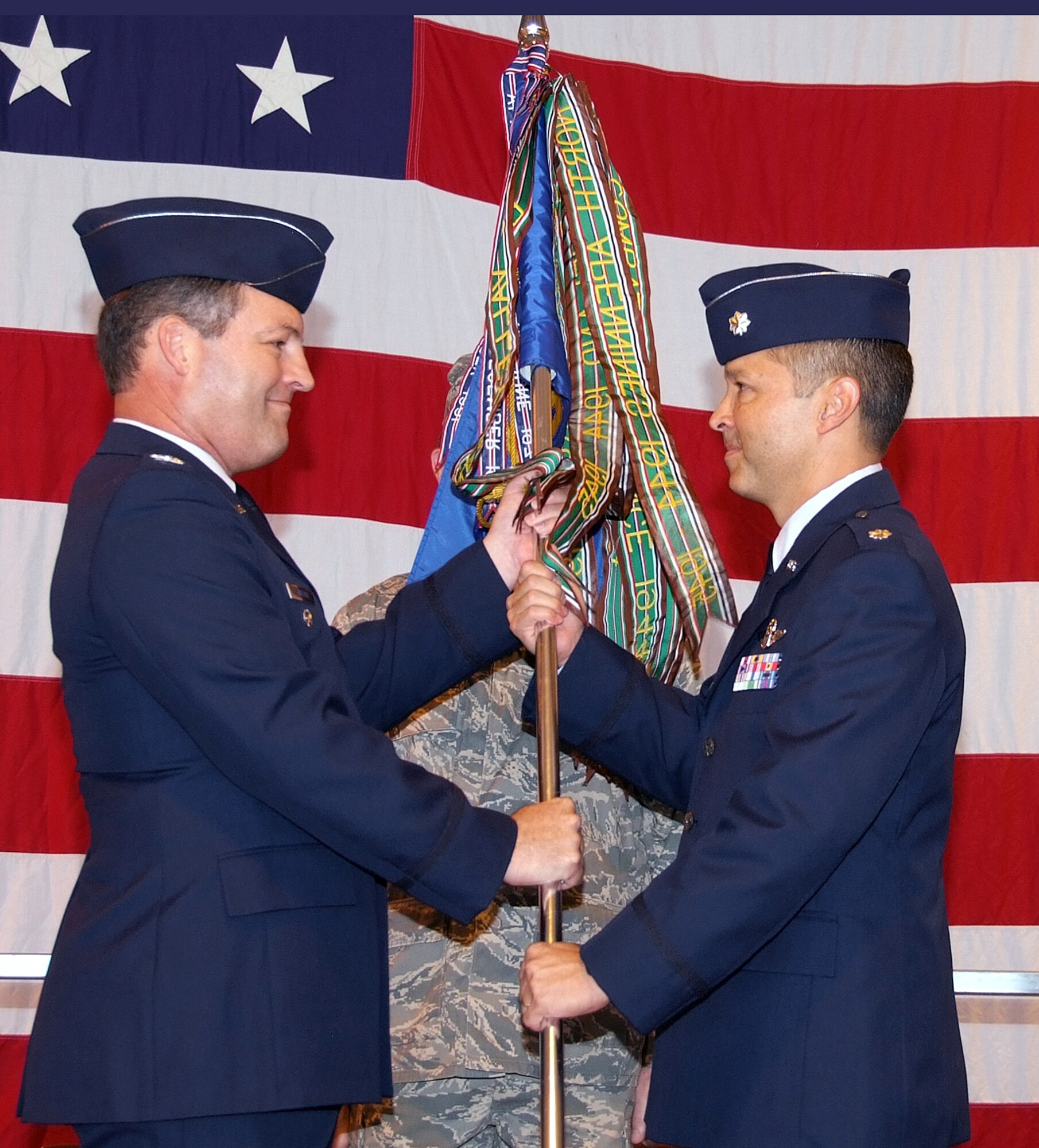 Lt. Col. Paul Tom, right, accepts the command of the 5th Flying Training Squadron from Col. James Smetzer, deputy commander of the 340th Flying Training Group at Randolph AFB, Texas, during a change of command ceremony held  Sept. 12 in Hangar 170 at Vance AFB, Okla. The former commander, Col. Kevin Kallsen, is taking as assignment as assistant director of operations with the 340th FTG.  The 5th FTS is an Air Force Reserve Command unit that augments all phases of flying training by providing qualified instructor pilots to the other flying squadrons at Vance. (U.S. Air Force photo by Terry Wasson)
