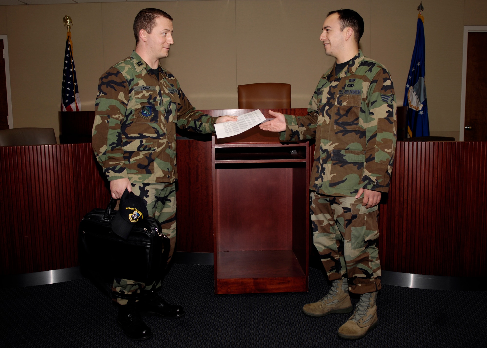 VANDENBERG AIR FORCE BASE, Calif. --  Capt. Jason Largey, Area Defense Council, hands papers to Senior Airman Shaun Bustillos, defense paralegal for the Area Defense Council, in the Courtroom in Bldg 10577 on Friday. (U.S. Air Force photo/Airman 1st Class Jonathan Olds)