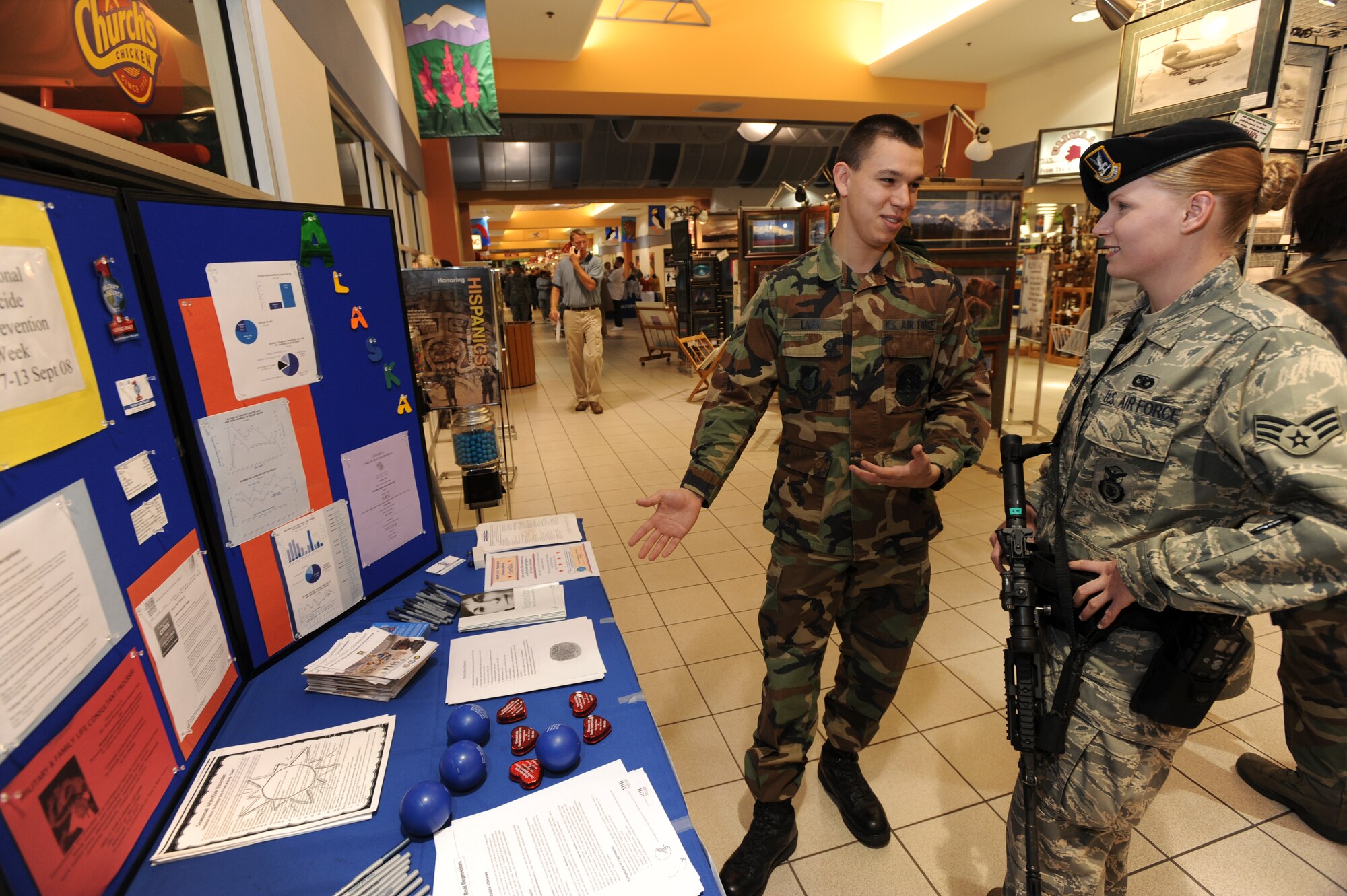 ELMENDORF AIR FORCE BASE, Alaska -- Senior Airman Holly Arant, 3rd Security Forces Squadron, receives a brief from Airman 1st Class Joseph Lara, 3rd Medical Operation Squadron, about suicide prevention at the Joint Military Mall Sept 12. Airman Lara, a mental health clinic technician, briefed mall patrons on ways of spotting and preventing suicides. The information booth was set up all week in support of Suicide Prevention month. (U.S. Air Force photo/Staff Sgt. Joshua Garcia)