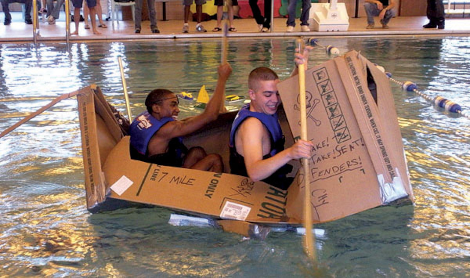 Airman 1st Class Martez Speed, 90th Missile Security Forces Squadron, and Airman Jason Perri, 90th MSFS, brace themselves as their cardboard boat begins to take on water during the competition.