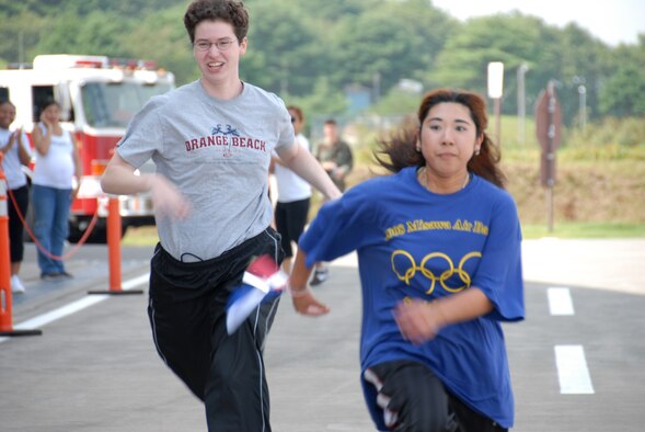 MISAWA AIR BASE, Japan -- Staff Sgt. Katrina Ball, 35th Maintenance Squadron, runs with Sachiko Tsujiura, Kakehashi-Ryo School, during the Misawa Air Base Special Olympics Sept. 13. Athletes were given a chance to run either a 50- or 75-meter dash. (U.S. Air Force photo by Senior Airman Laura R. McFarlane)