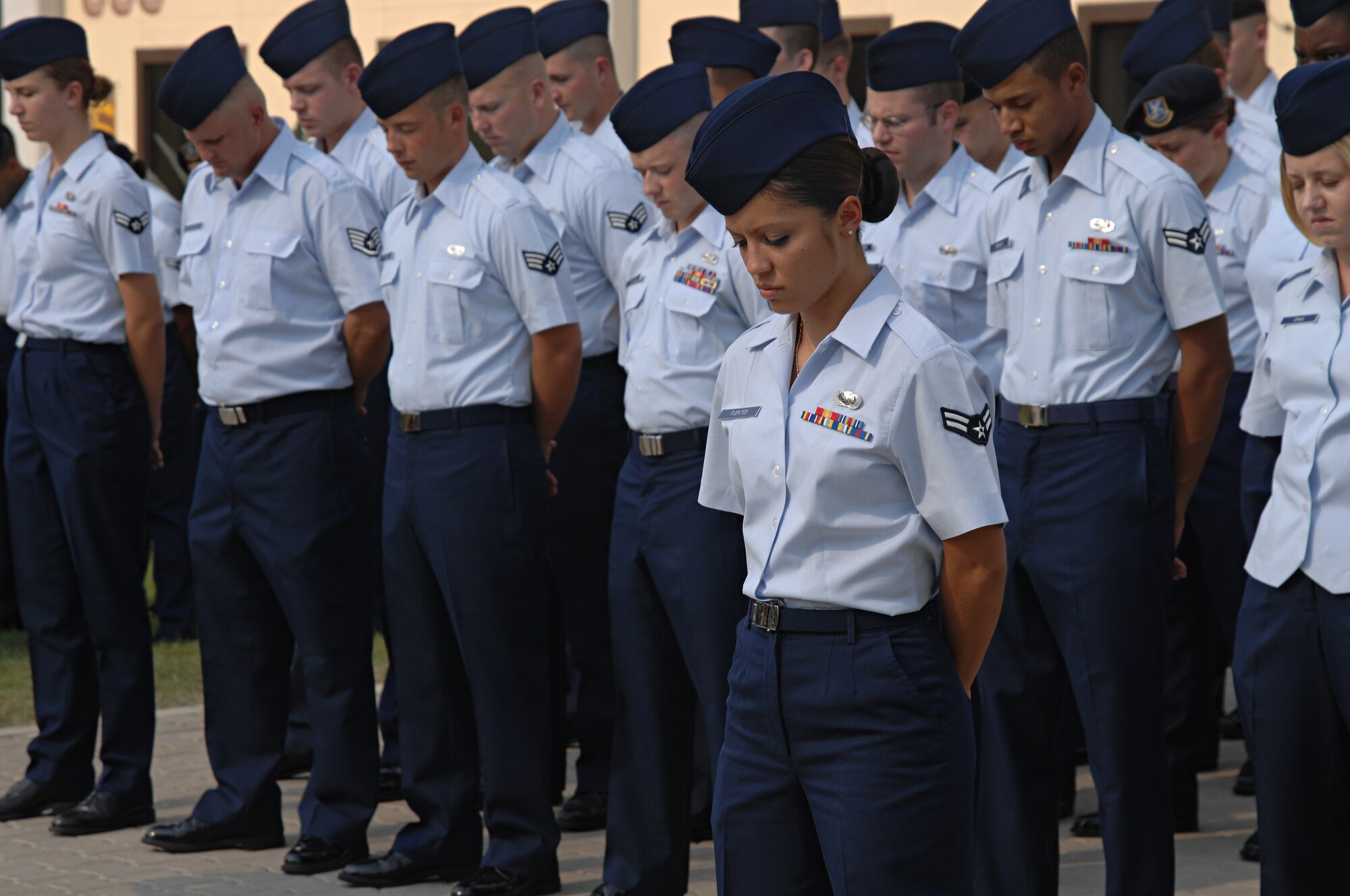 Airman 1st Class Vanessa Fuentes, Detachment 7 Air Force News Agency, stands in front of a flight and observes a moment of silence during a memorial service held Sept. 11 in honor of the victims of 9/11. (U.S. Air Force photo by Senior Airman Benjamin Wilson)