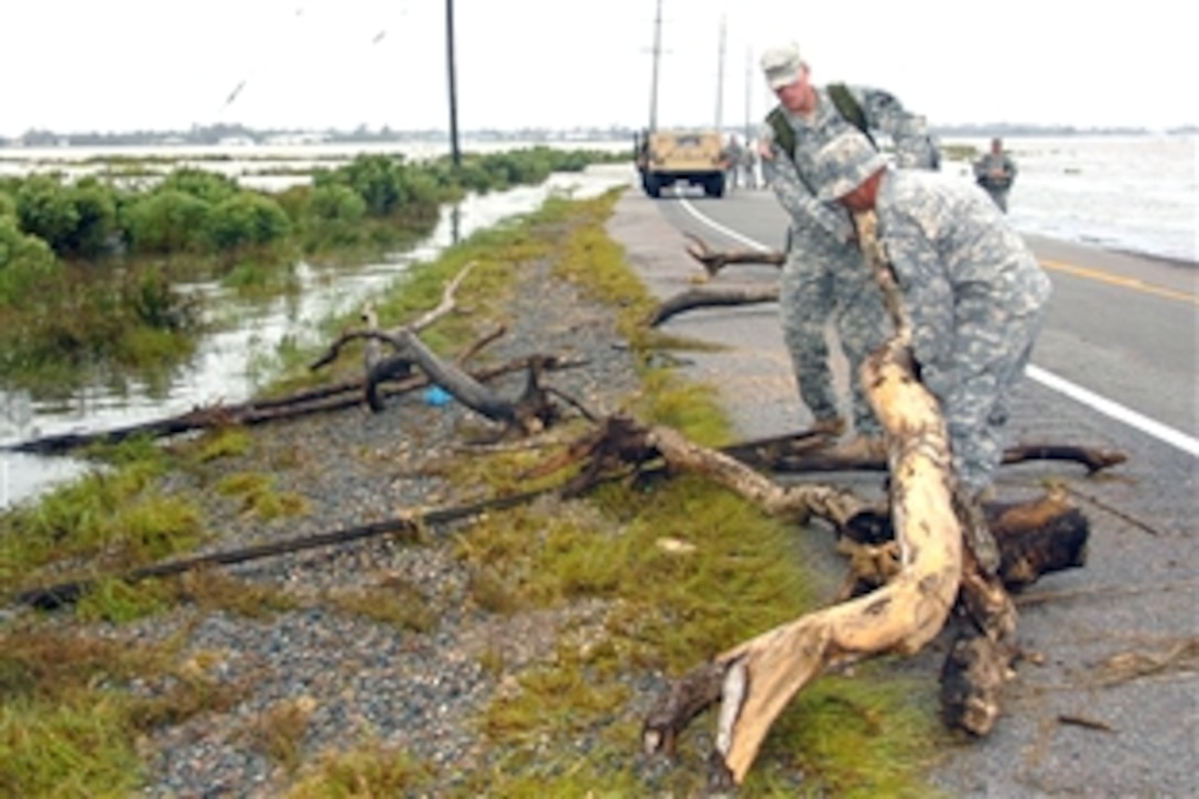 Louisiana Army National Guardsmen of the 205th Engineer Battalion remove debris from a highway in Sulfur, La., on Sept. 14, 2008. Today, Sept. 15, about 1,400 of these mobilized aoldiers and airmen who are secondary education students were allowed to return home in order to resume studies.  