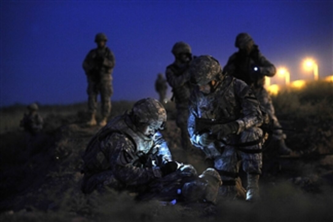 U.S. Army 2nd Lt. Chang Ahn, leader of 2nd Platoon, 5th Battalion, 82nd Field Artillery Regiment, and Maj. David McCulley, battalion operations officer with the 5th Battalion, 82nd Field Artillery Regiment, update perimeter maps to increase base security at Joint Base Balad, Iraq, on Sept. 11, 2008.  The operation is a joint patrol designed to introduce Security Forces airmen to the base's outer perimeter prior to the airmen taking responsibility of the area from the Army unit.  