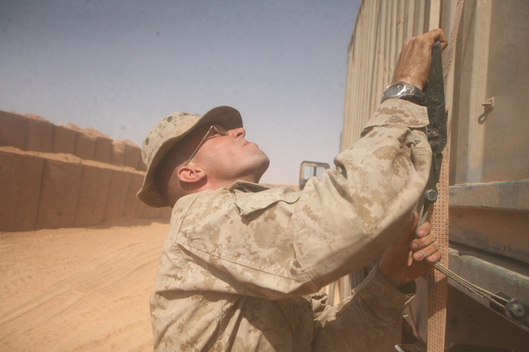 Cpl. Kreg A. Pringle, a line noncommissioned officer from Eldridge, Mo., with Motor Transportation Platoon, Headquarters and Service Company, 2nd Light Armored Reconnaissance Battalion, Regimental Combat Team 5, loosens a strap of a large container holding materials during a resupply mission in western al-Anbar province, Iraq, Sept. 16. The Marines with Motor-T have supplied an area approximately the size of South Carolina since the beginning of their deployment more than 6 months ago.