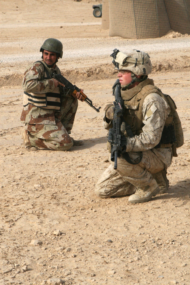 An Iraqi Army soldier provides security alongside Lance Cpl. Kevin Izor, a rifleman with Company F, Task Force 2nd Battalion, 2nd Marines, Regimental Combat Team 5, during a rehearsal exercise for an upcoming mission at Combat Outpost Rawah, Iraq, Sept. 16. Company F, along with IA personnel, conducted a mission to search for a known improvised-explosive-device maker.