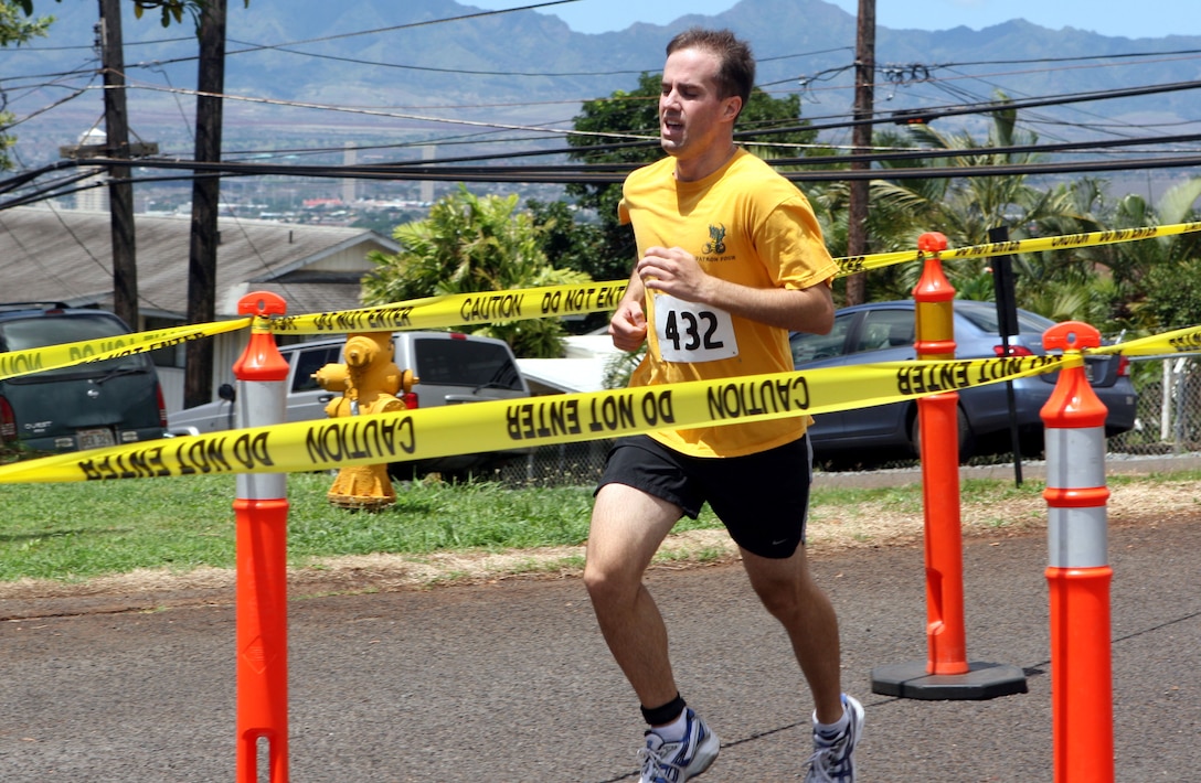 Brian Harrington charges over the finish line finishing the race first with a time of 20:16, during the 12th annuel 5K Grueler Sept. 17.