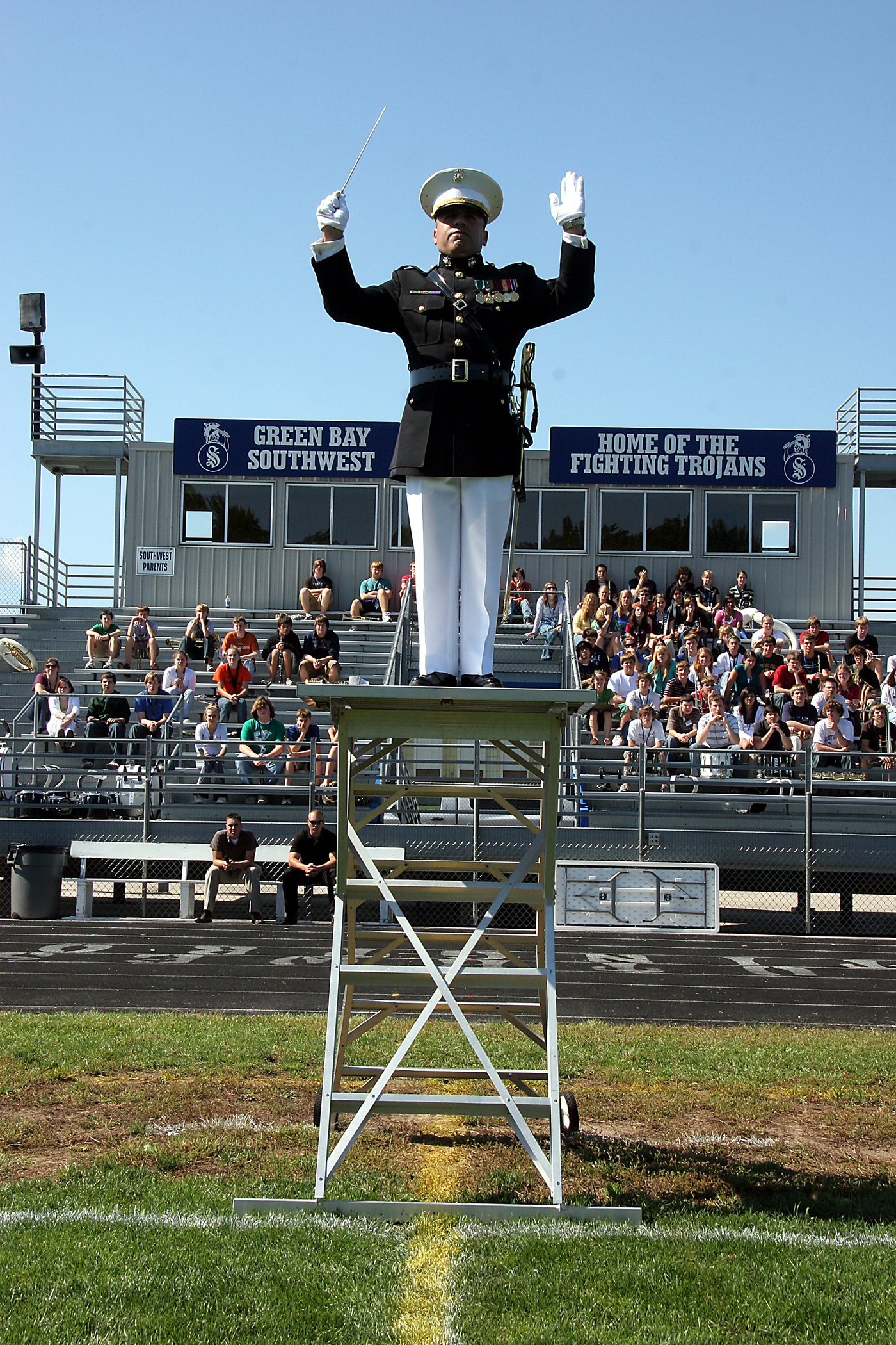 Chief Warrant Officer 2 Stephen Giove, band director for the MCAGCC 29 Palms Band, uses a platform to direct the band during a field performance for the students of Southwest High School in Green Bay, Wis., Sept. 17.  The band conducted nearly 20 performances at 13 venues throughout the state during their week long tour.