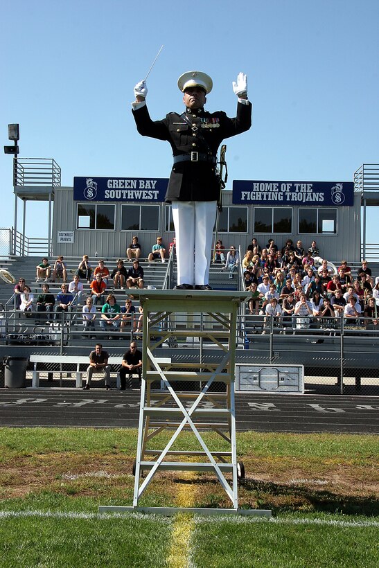 Chief Warrant Officer 2 Stephen Giove, band director for the MCAGCC 29 Palms Band, uses a platform to direct the band during a field performance for the students of Southwest High School in Green Bay, Wis., Sept. 17.  The band conducted nearly 20 performances at 13 venues throughout the state during their week long tour.