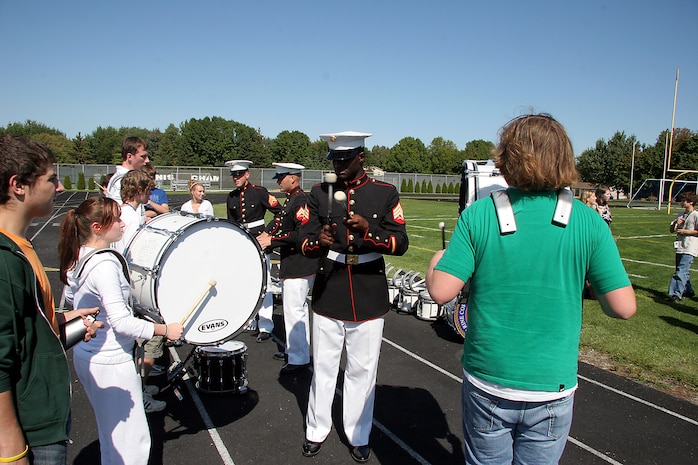 Sergeant Douglas Hardee, a percussionist with the MCAGCC 29 Palms Band, keeps time for two percussionists with Southwest High School Band in Green Bay, Wis., Sept. 17.  During a brief clinic with the school band, Hardee works with fellow bass drummer on keeping time, since the set the beat for marches.