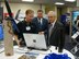 Deputy Secretary of Defense, Gordon England (right), Deputy Secretary of Defense, and Michael Donnelly (center), Secretary of the Air Force, listen to Brian Mitchell, Air Force Research Laboratory Munitions Directorate, as he describes solutions being developed for the problem of helicopter brownout at the national Air Force Association conference in Washington D.C. Sept. 15 through 17. (U.S. Air Force photo by Mike Wallace)                               