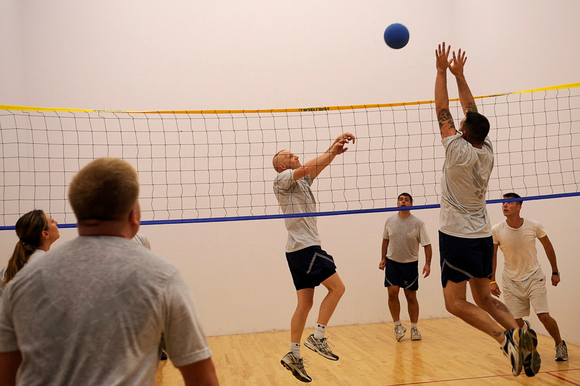 BUCKLEY AIR FORCE BASE, Colo. -- A member from the 460th Mission Support Squadron goes up to block a shot from a member of the 460th Space Communications Squadron in a wallyball match here during the Team Buckley Sports and Field Day, Sept. 12, at the base Fitness Center. Events were originally scheduled to take place outside, but inclement weather forced sports day inside. Wallyball was played in place of sand volleyball. (U.S. Air Force photo by Tech. Sgt. Jeromy Cross)