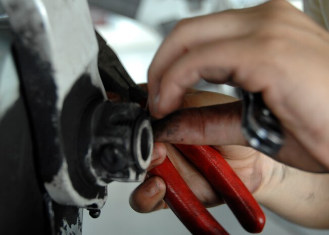 Senior Airman Marlene Roque removes the retaining bolt from a landing gear support fixture at the home station check hangar on Charleston AFB. Maintenance Airmen at the HSC hangar fully inspect an average of three C-17s a week.  Airman Roque is a crew chief with the 437th Maintenance Squadron. (U.S. Air Force photo/Airman 1st Class Katie Gieratz)