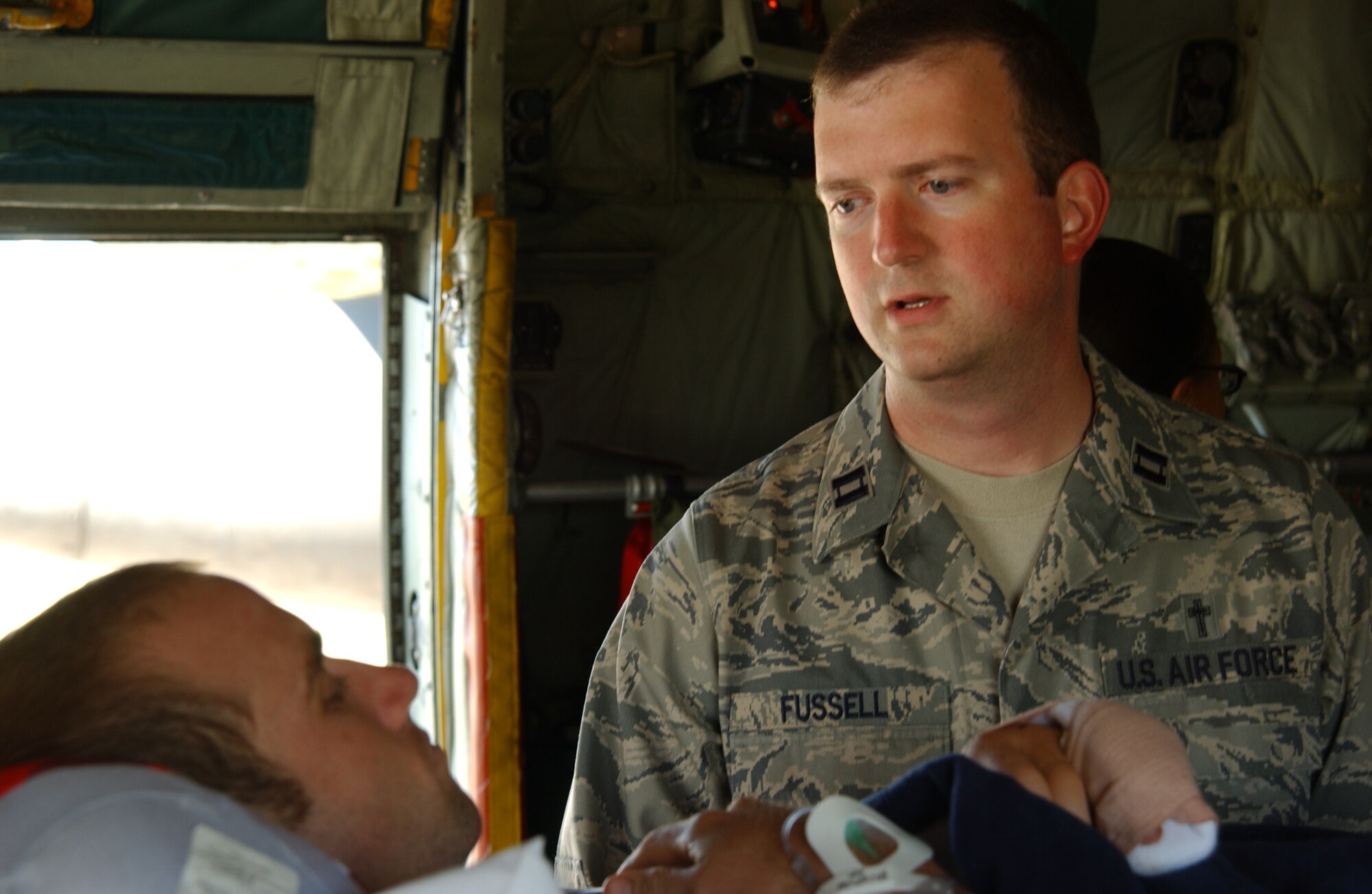 SCOTT AIR FORCE BASE, Ill. -- Chaplain Fussell, 375th Airlift Wing chaplain, speaks to a patient onboard a C-130 from Pope Air Force Base, N.C. Sept. 10, as the crew departs from Scott to take the patient home. Chaplain Fussell flies on the plane to aid in the spiritual healing of the patients, as well as, the air and medical crews. 
(US Air Force photo/Airman 1st Class Amber Kelly-Woodward)