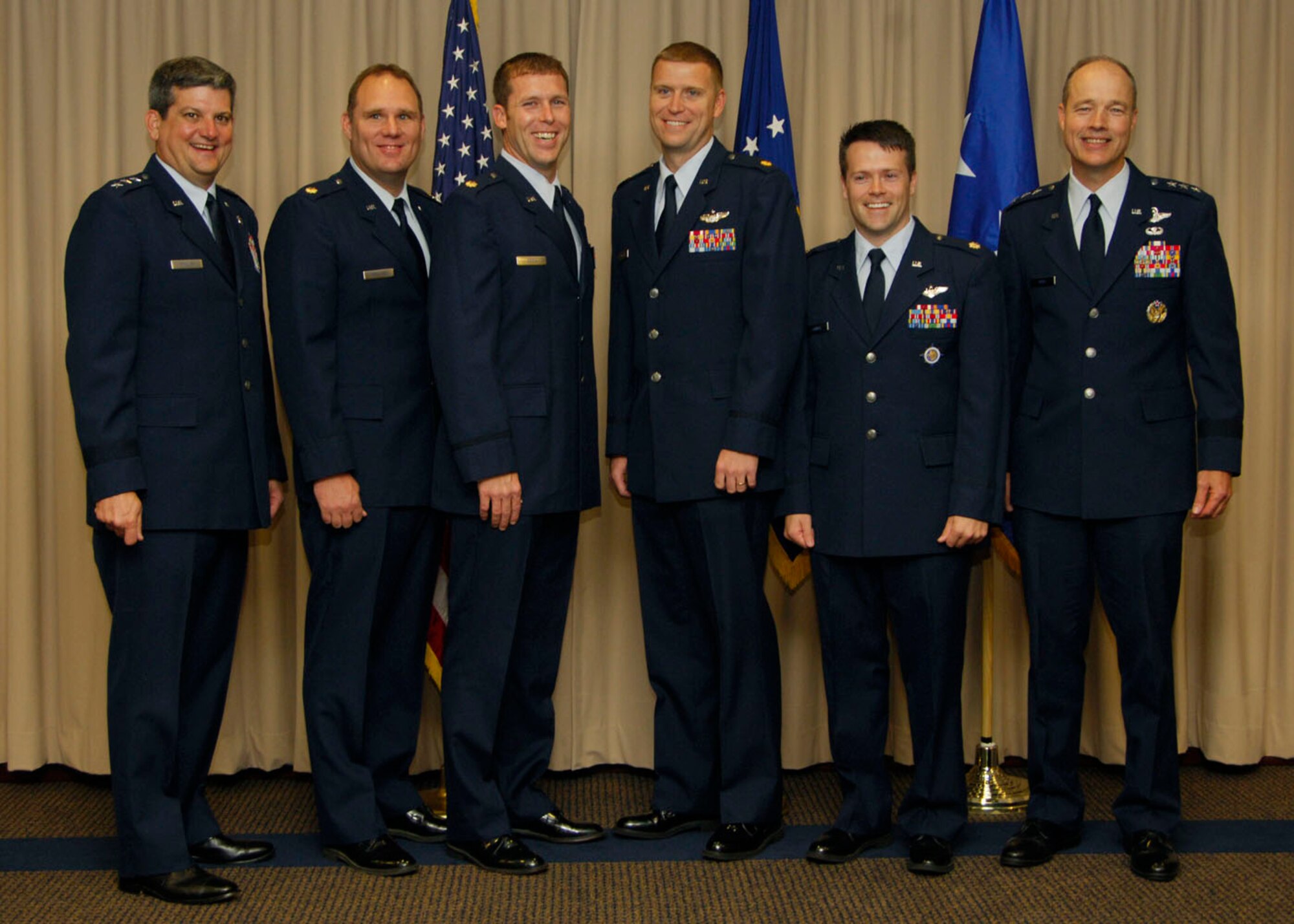 SCOTT AIR FORCE BASE, Ill. -- Pictured above, the first Air Force Fellows Joint Mobility Intern Program graduates: Maj. Donald Kirkland, Maj. David Owens and Maj. Brett Sowell are pictured with Lt. Gen. Vern “Rusty” Findley (far left), Air Mobility Command vice commander, and Lt. Gen Allen Peck (far right), Air University commander. 
(US Air Force photo/Airman 1st Class Wesley Farnsworth)