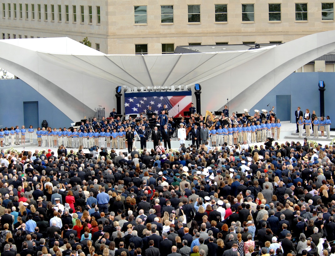 The U.S. Air Force Band leads the official party and audience in singing "God Bless America" at the Pentagon Memorial Dedication Ceremony, Sept. 11, 2008. The national memorial is the first to be dedicated to those killed at the Pentagon on Sept. 11, 2001. The site contains 184 inscribed memorial units honoring the 59 people aboard American Airlines Flight 77 and the 125 in the building who lost their lives that day. (Defense Dept. photo by Air Force Master Sgt. Adam M. Stump)