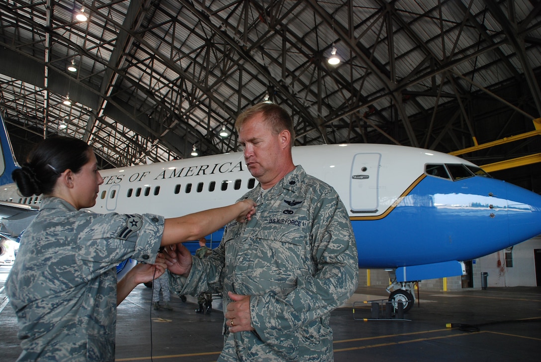 Former 932nd Airlift Wing Maintenance Group commander Lt. Col. Kirk Peddicord, gets a microphone hooked up during the filming of a documentary for the Air Force Reserve Command's Illinois wing.  Behind him is a C-40C plane belonging to the wing.  (U.S. Air Force photo by Maj. Stan Paregien)