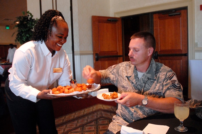 Velva Morton offers hush puppies to Senior Master Sgt. Brian Davis at a membership drive event at the Charleston Club Sept. 15. The club is promoting an ongoing membership drive which offers extra benefits to base members who become club members. Ms. Morton is a banquet server with the club and Sergeant Davis is the 437th Civil Engineer Squadron Operations Flight superintendent. (U.S. Air Force photo/Staff Sgt. Sam Hymas)