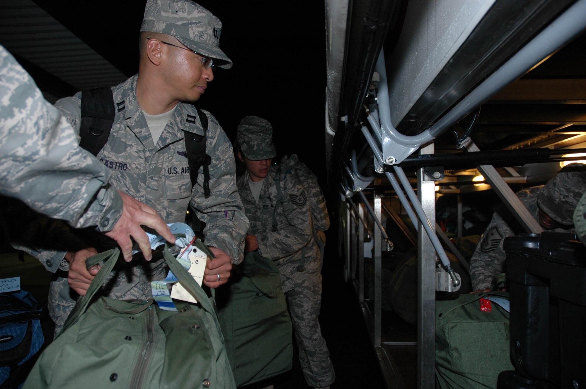 MCGUIRE AIR FORCE BASE, N.J. -- Capt. Dennis Castro, a flight nurse with the Reserve 514th Aeromedical Evacuation Squadron, helps load baggage onto a bus Saturday prior to departing on a 120-day deployment to Iraq. This fall about 50 Citizen Airmen from McGuire AFB are scheduled to participate in four-month deployments supporting the Global War on Terrorism. (U.S. Air Force photo/Master Sgt. Donna T. Jeffries)