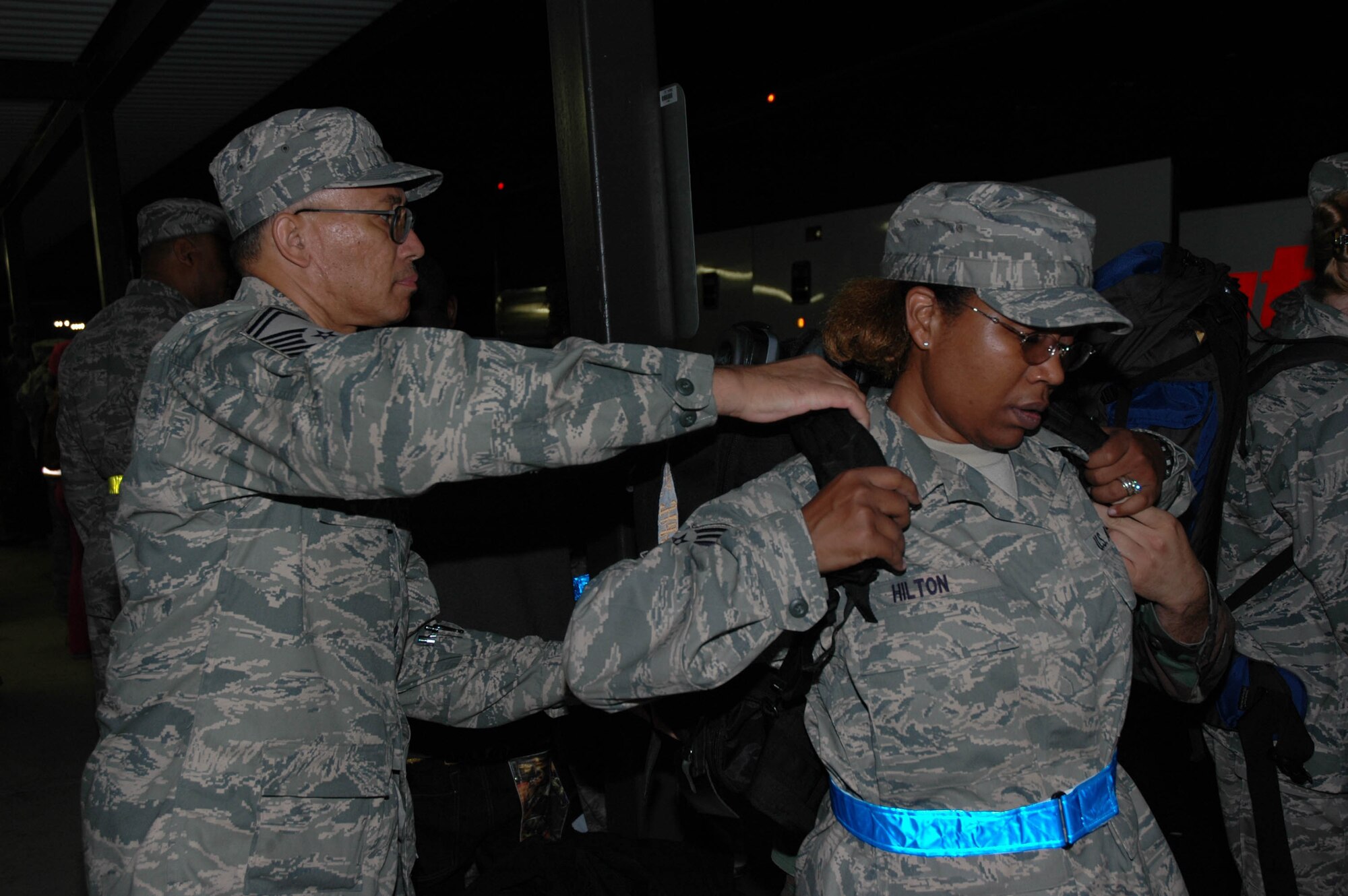 MCGUIRE AIR FORCE BASE, N.J. -- Tech. Sgt. Daphne Hilton, a medical administrator with the Reserve 514th Aeromedical Evacuation Squadron, gets assistance from Senior Master Sgt. Mark G. Johnson, Saturday prior to departing on a 120-day deployment to Iraq. This fall about 50 Citizen Airmen from McGuire AFB are scheduled to participate in four-month deployments supporting the Global War on Terrorism. (U.S. Air Force photo/Master Sgt. Donna T. Jeffries)