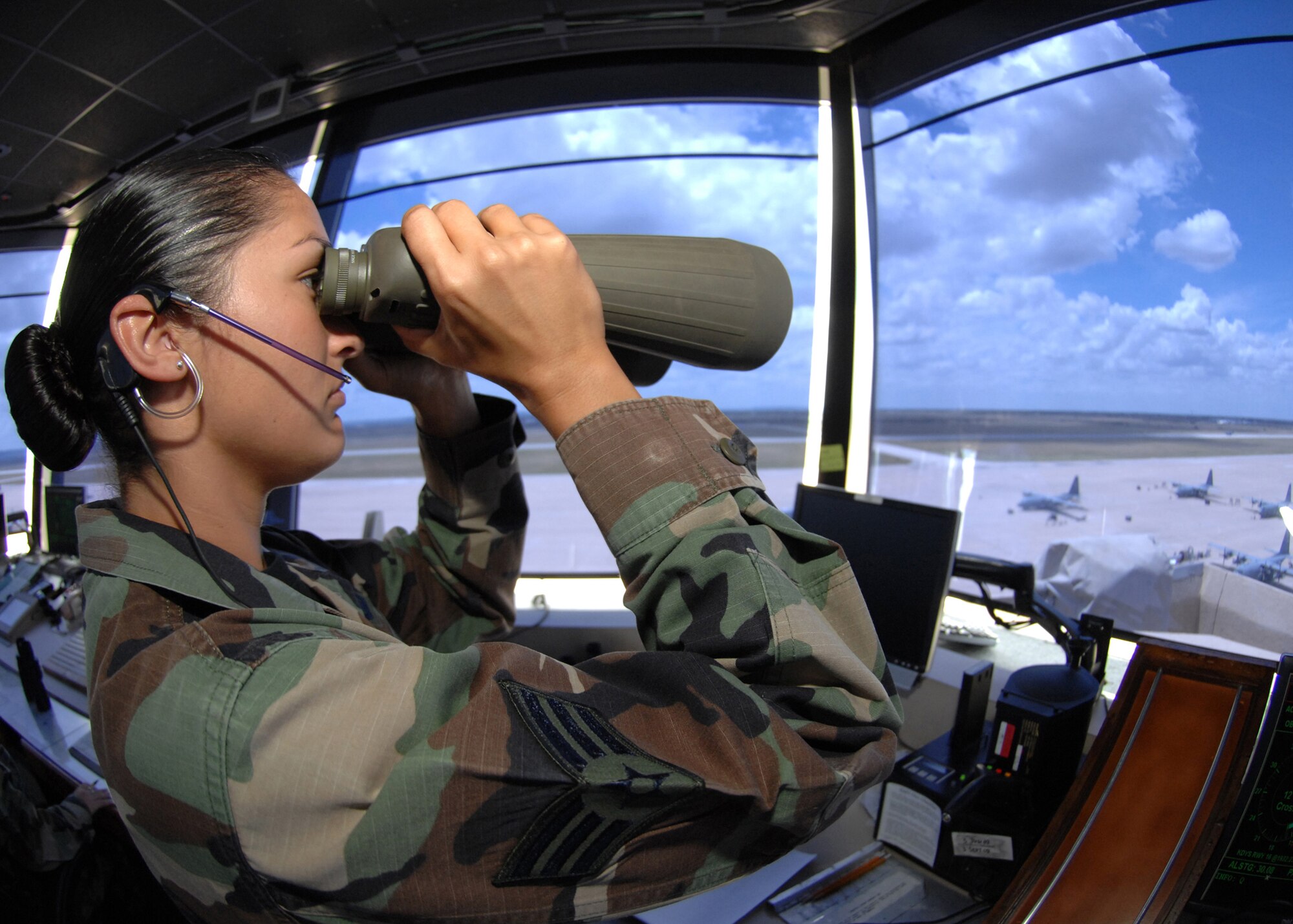 DYESS AIR FORCE BASE, Texas -- Senior Airman Malena Rathbone, from the 7th Operations Support Squadron, uses binoculars to observe flightline operations from the air traffic control tower here, Jul. 9.  Situational awareness is the key to being an Air Traffic Controller while working 8 - 12 hour shifts.  The 7th Operations Group has a vital role in completing the wing mission and ensuring the success of Team Dyess. (U.S. Air Force photo/Airman 1st Class Stephen Reyes)